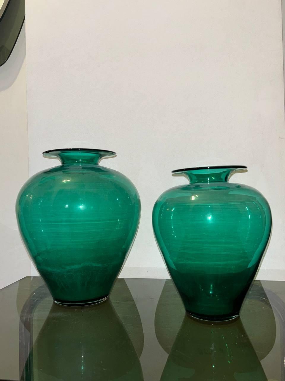 Aggiungete un tocco di autentico design italiano Mid-Century Moderno alla vostra casa con questa splendida coppia di vasi firmati (presumibilmente, da verificare) dalla celebre vetreria Venini di Murano. Risalenti agli iconici anni '60, questi vasi
