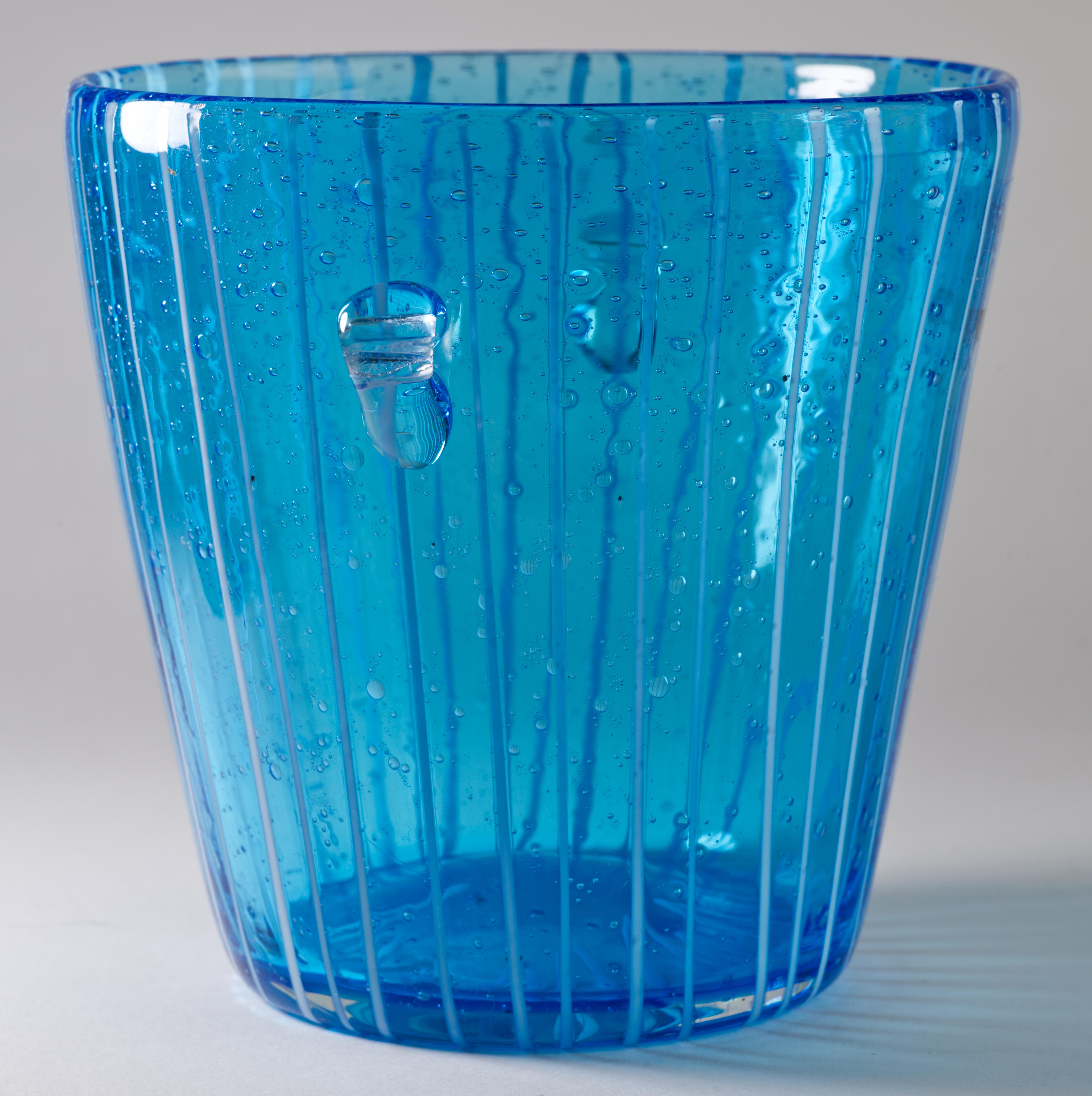  Modernist vintage ice bucket has abstract geometric decor of fused white glass on transparent blue colored glass with controlled bubbles effect. The piece has two small rounded handles done in clear glass and attached separately.

The ice bucket is