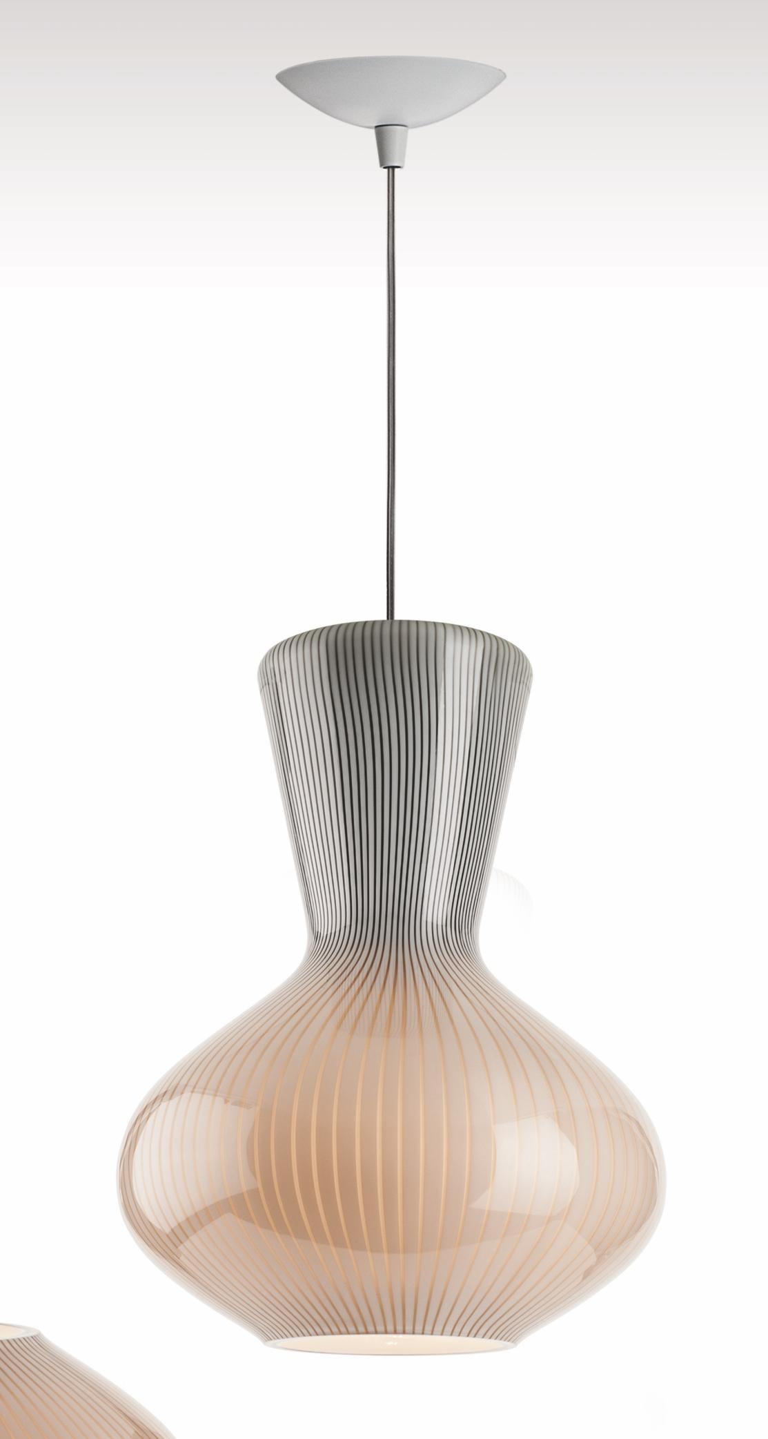 Glass hanging pendant or suspension light with an interesting shape and two-tone coloring. Its sleek design and muted color pallette make it a modern, simple and understated lighting option for any space. Also available as a table lamp.

Light