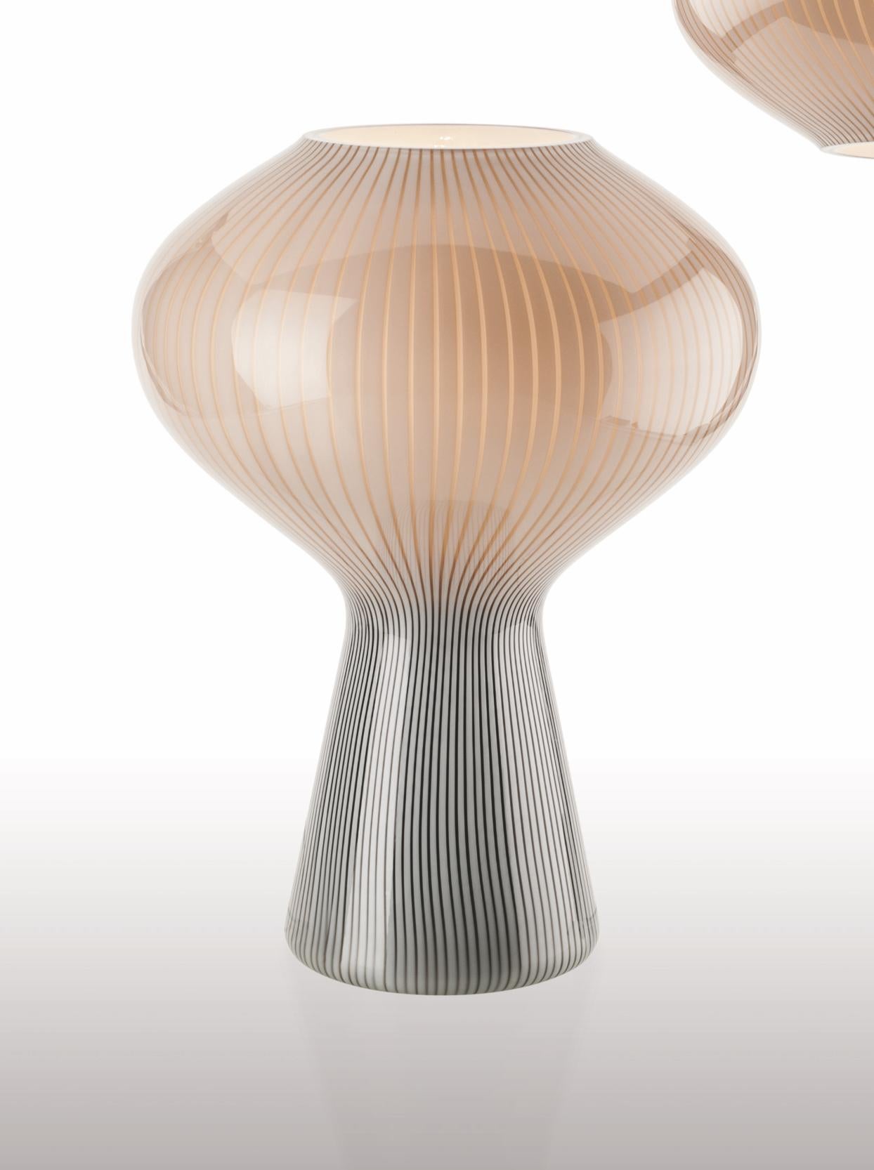 Glass table lamp with an interesting shape and two-tone coloring. Its sleek design and muted color pallette make it a modern, simple and understated lighting option for any space. Also available as a pendant light. 

Light source: One max E27