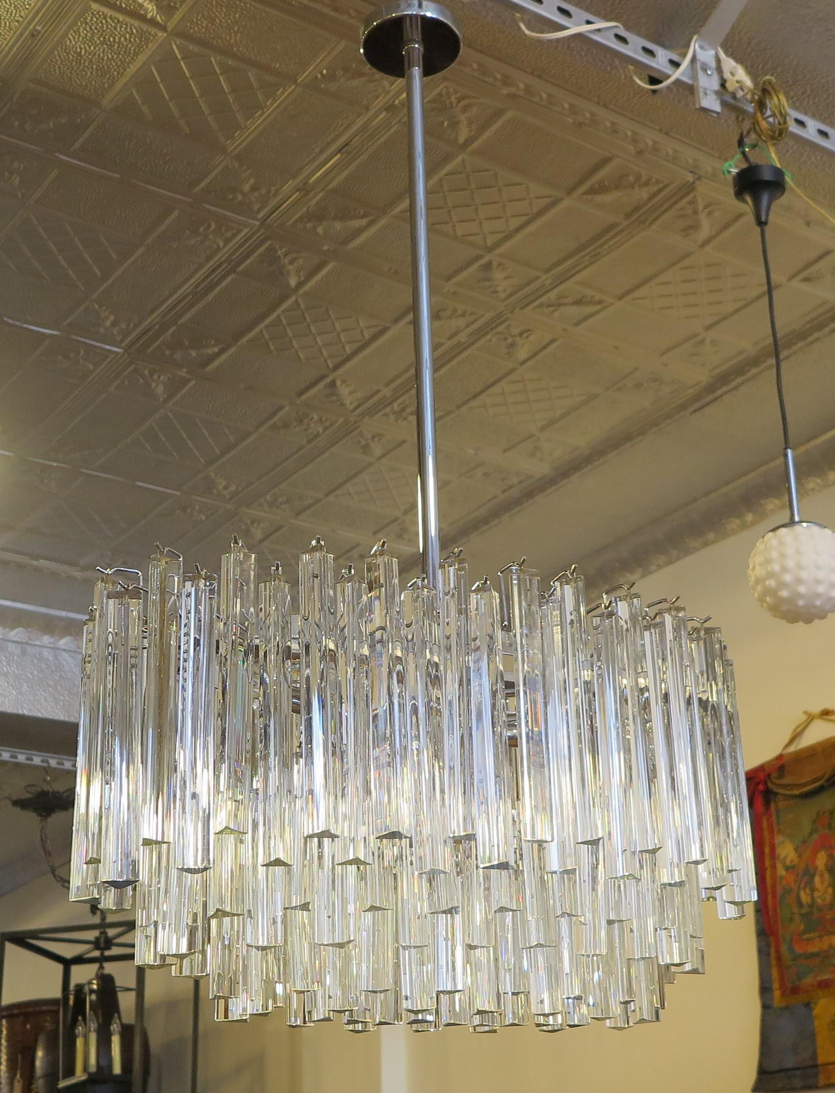 A spectacular Venini Murano glass chandelier comprised of individually handblown Murano glass triangular triede crystal prisms. Chrome frame supports 6 different height tiers in an graduated oval. The oval arrangement is special working perfectly in