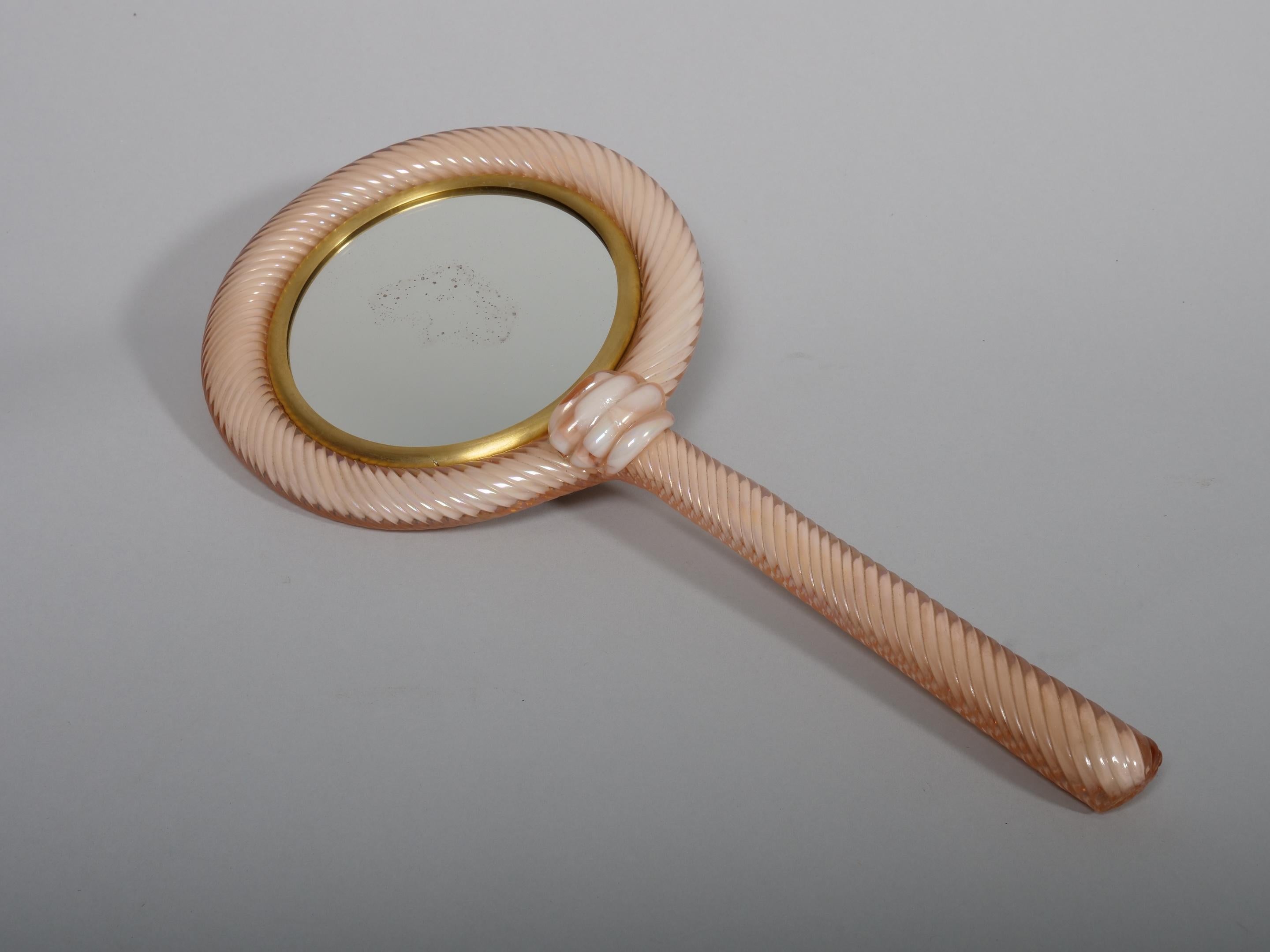 Really beautiful. Rare, Venini (probably),  hand mirror. 

Pale pink twisted rope glass. 

The mirror has some minimal age marks. Mirror is framed with a brass rim and the pink twist glass is near perfect condition. 


A small hook has been attached