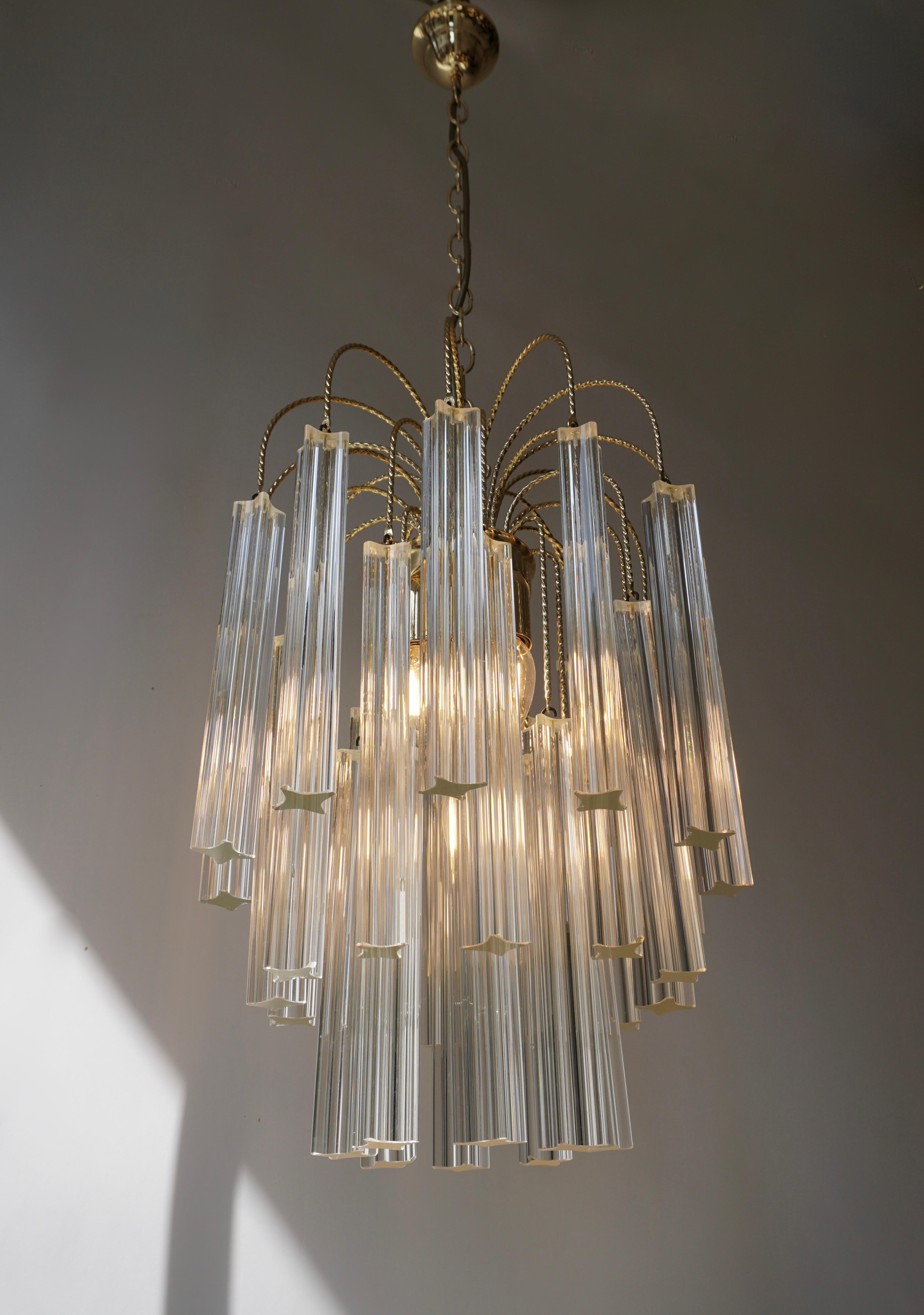 Beautiful Venini multi-tier four-light chandelier featuring four point (Quatro Punta) angle cut-crystal and brass-plated steel frame. Uses four E14 - 40 watt candelabra size bulbs.

Measures: Diameter 35 cm.
Height fixture 53 cm.
Total height