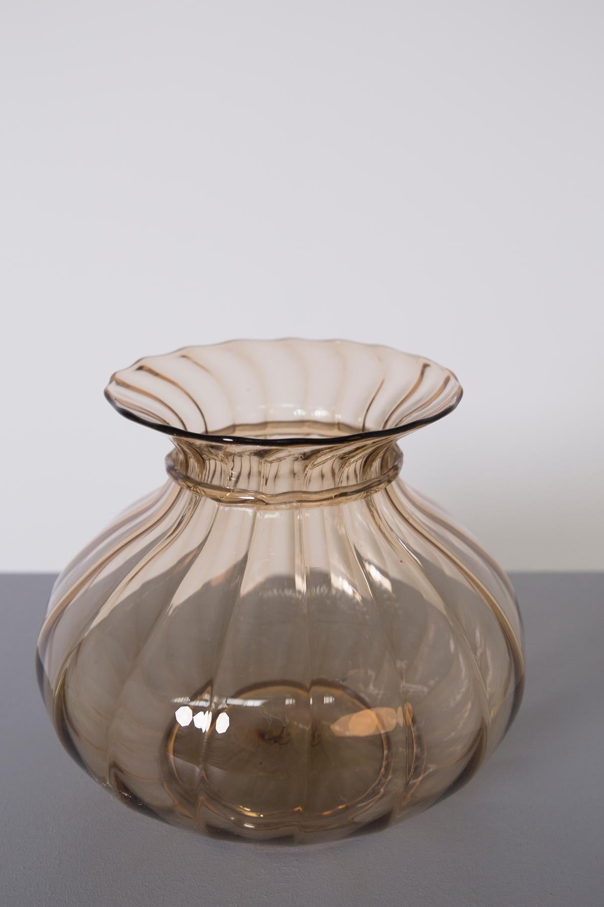 Elegant Murano vase made by Venini in 1925. 
The vase is in clear amber and ribbed colored glass, with a slight torchon near the mouth of the vase. The vase is Mod. 3104 for Venini of 1925/26. Acid-etched signature on the base: Venini Murano.