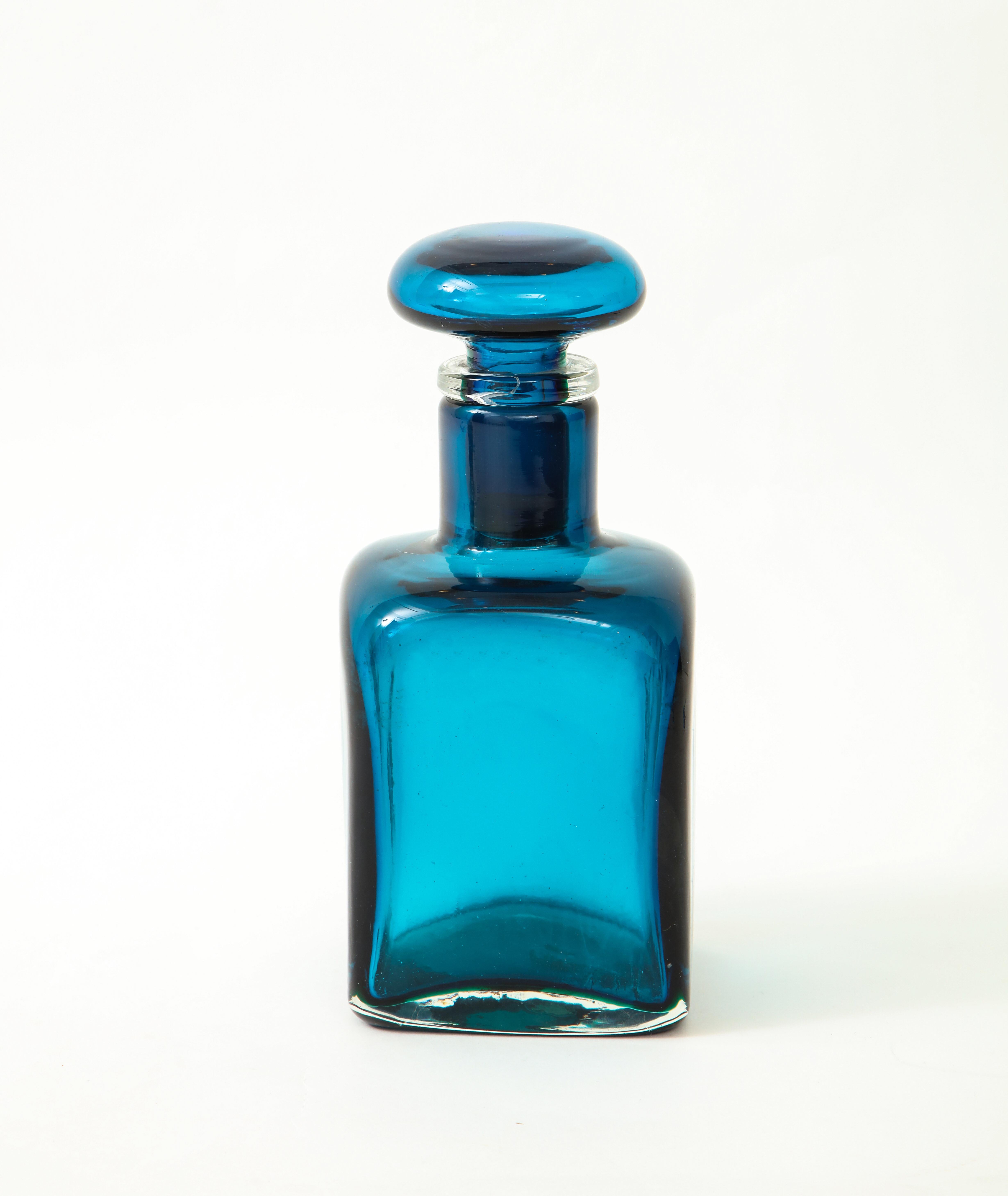 Large bottle with square base in oceano (ocean) blue composite glass with several layers of color and stopper, Italy, 1950s.

Literature:
Marino Barovier, Carla Sonego, Paolo Venini e la sua fornace, Skira, Milano, 2016, 
p. 275.
