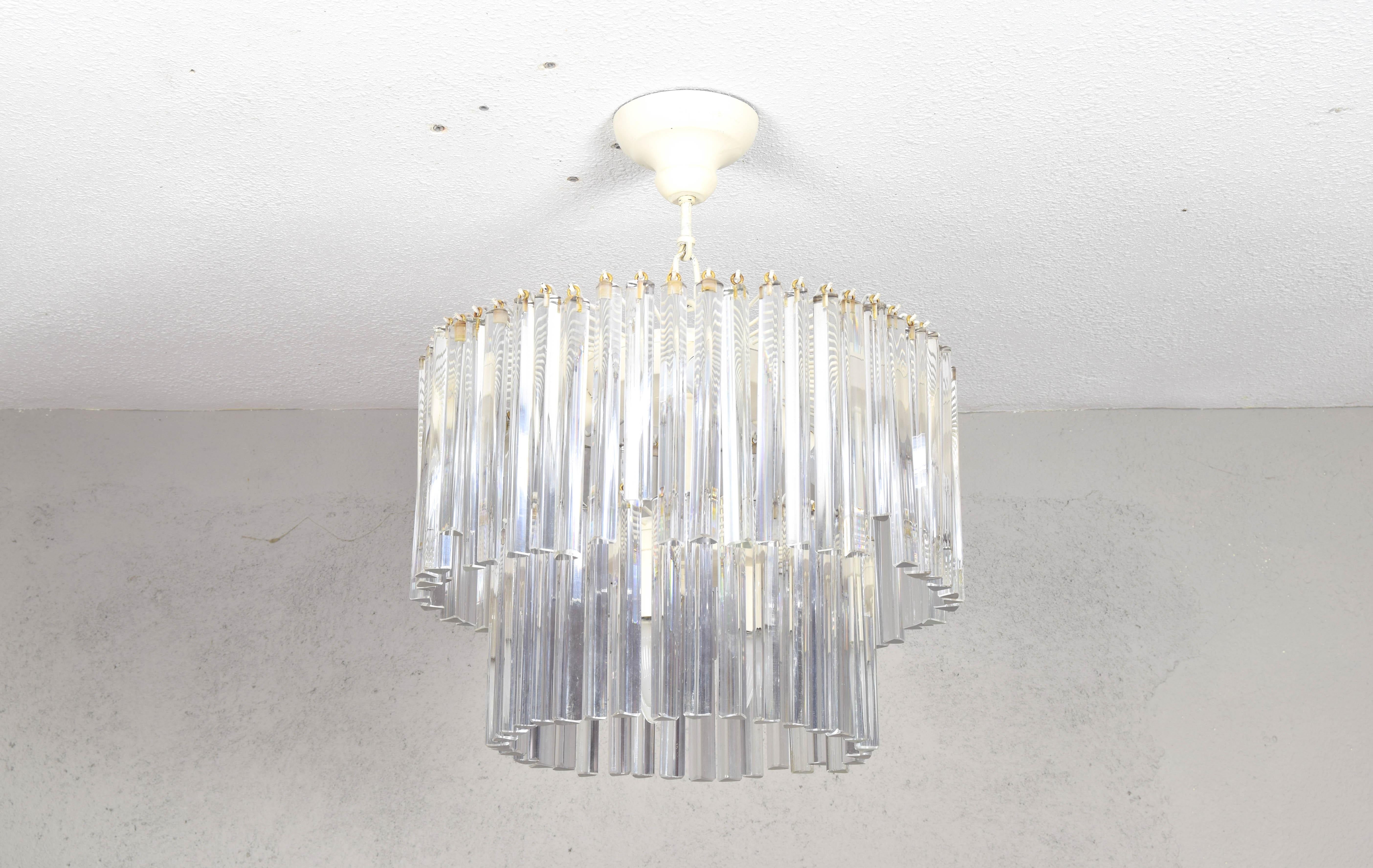 Italian chandelier from Venini.
This chandelier is made up of a steel structure in two heights, originally brass, it has been refinished in matte white, which although it is not its original finish, it is no less true that it gives a unique and soft