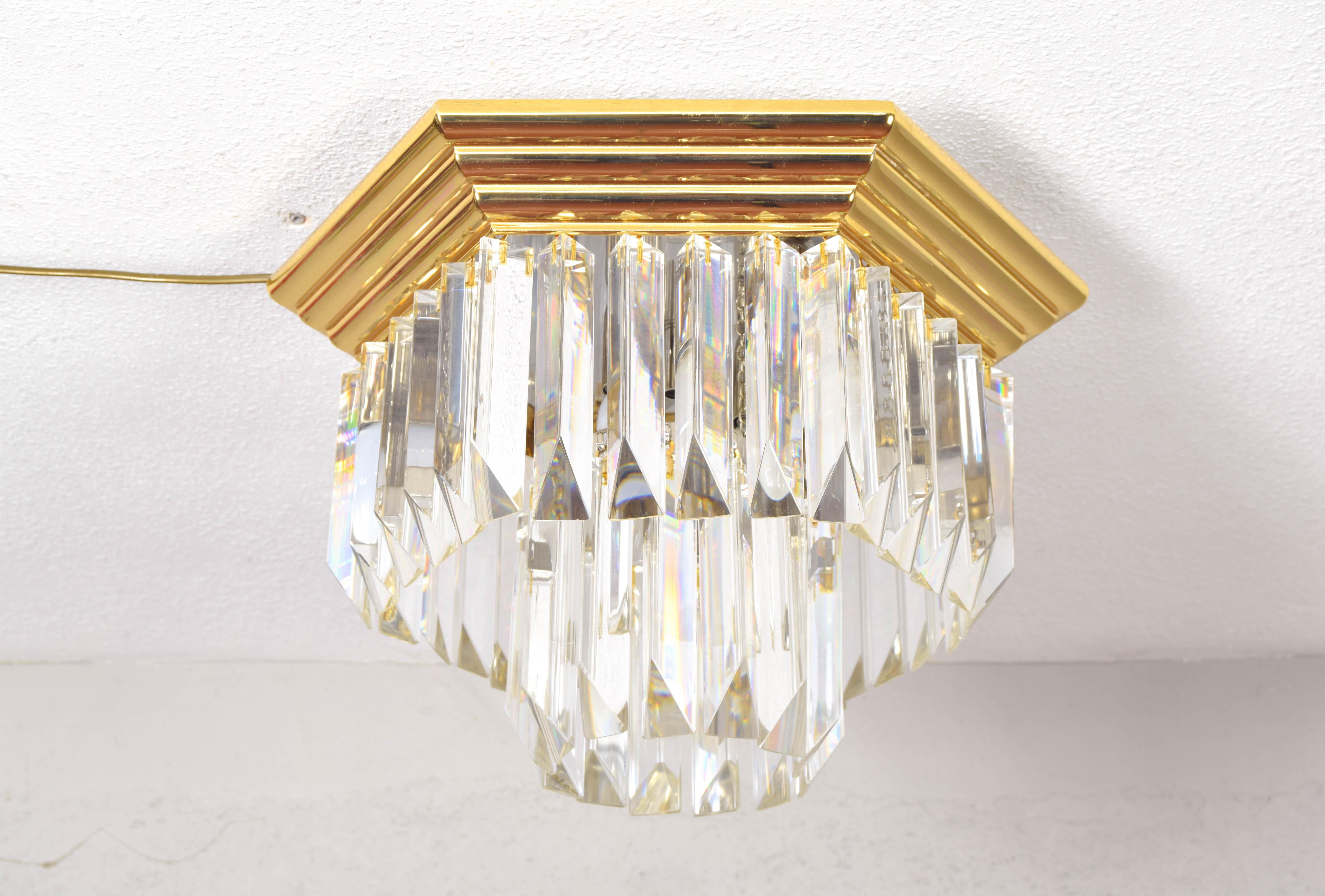 Magnificent Italian flush mount lamp by Venini.
This hexagonal ceiling light consists of a brass and steel structure with two heights and six E14 bulbs.
Composed of 43 beautiful Triedri crystals in very good condition with practically no
