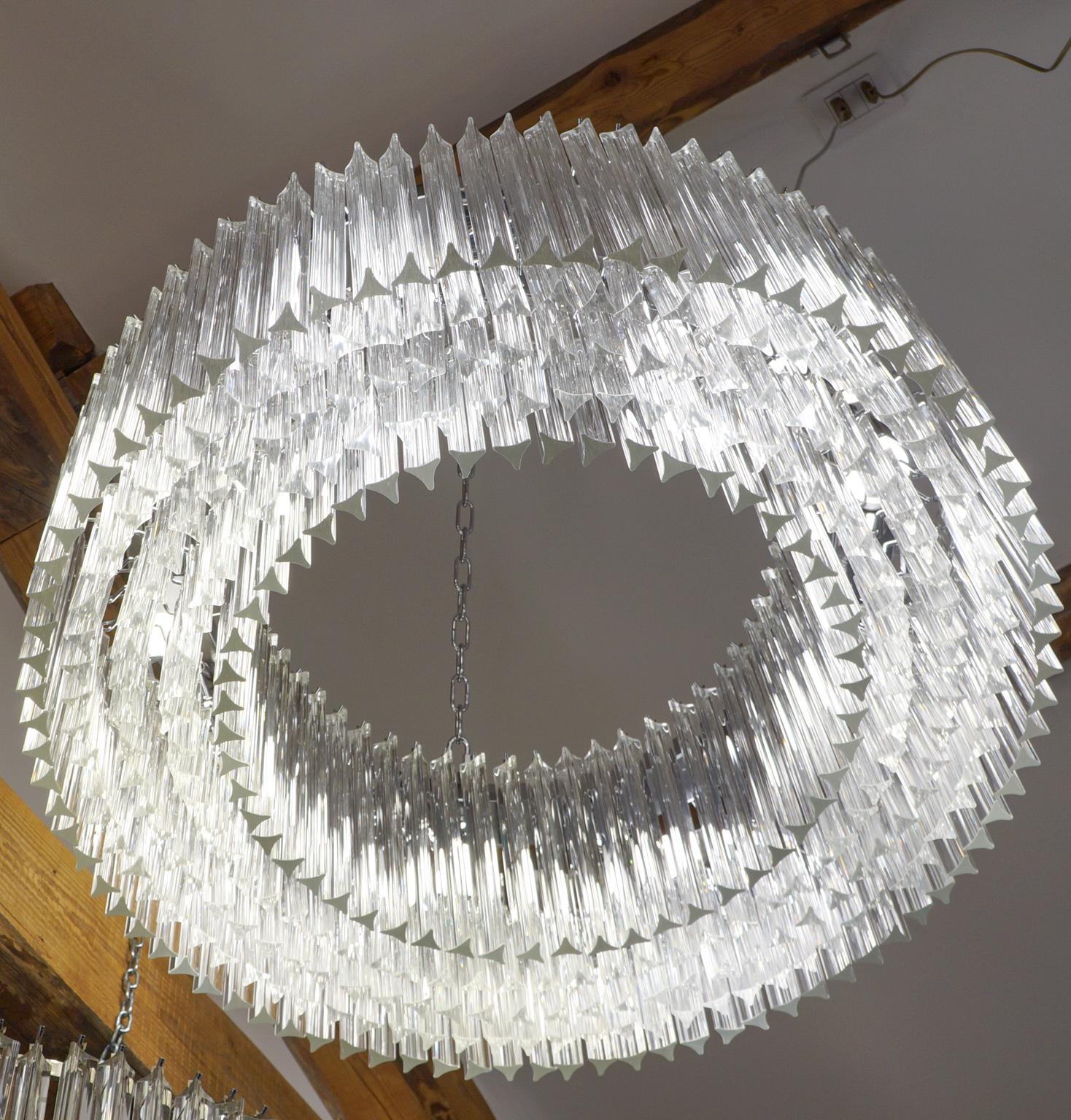 Murano glass chandelier with 370 elements in crystal, nickel finish structure and nine E26 / E27 bulbs. The elements of this typical chandelier are called Triedri, for its triangular shape. The assistants take a small quantity of glass from the