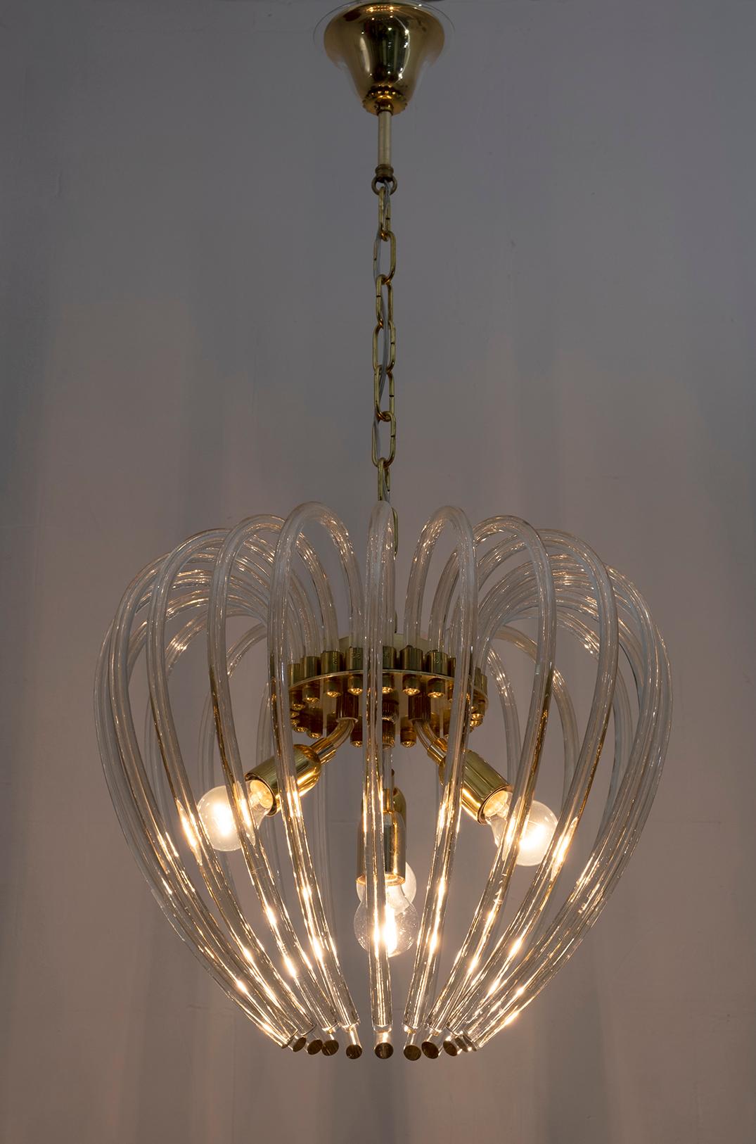 Rare example of a Murano glass and brass chandelier, produced by Venini in the 1950s. Twenty-two curved arms in Murano crystal. Four E27 bulbs.