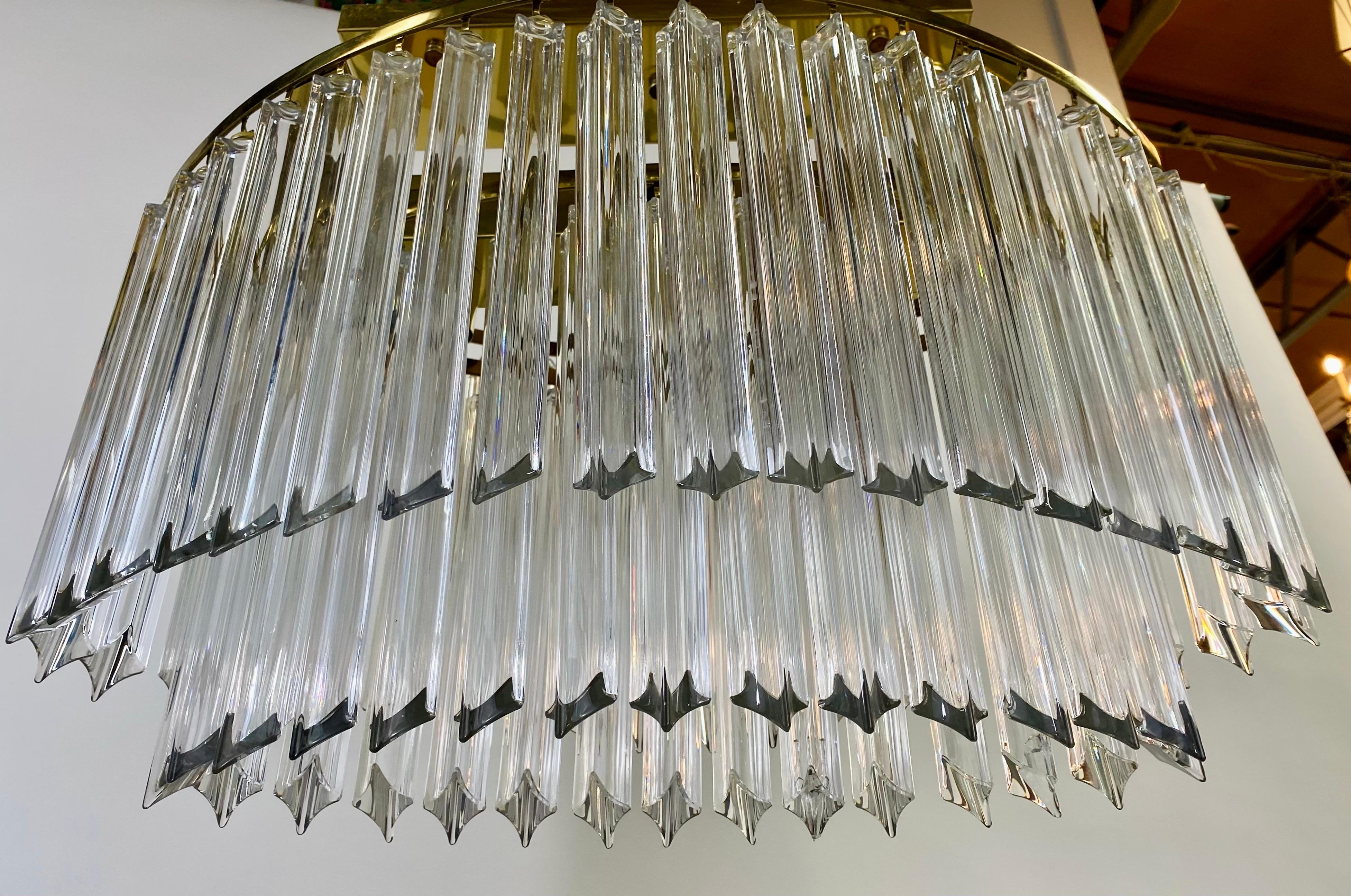 An exceptional Mid- Century Modern oval chandelier by Venini ( Founded 1921 in Milan, Italy by Paolo Venini and Giacomo Cappellin). The stylish two-tiered chandelier features hand-blown Murano glass triede elongated prisms that dance in the light