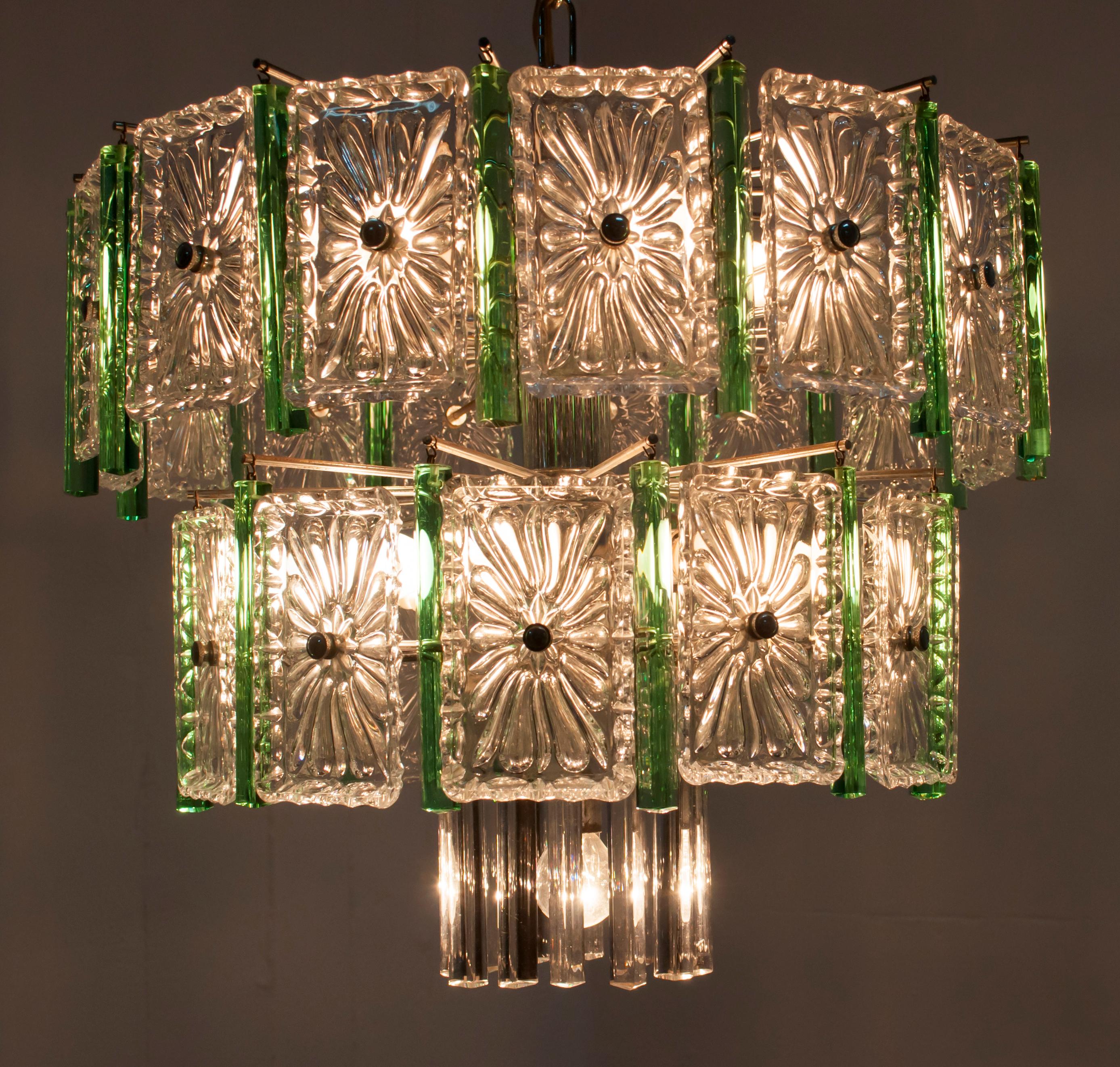 This 12-light chandelier, produced by Venini in the 1960s, features prisms in green and transparent Murano glass and transparent tiles.

Paolo Venini (1895-1959) emerged as one of the leading figures in the production of Murano glass and an