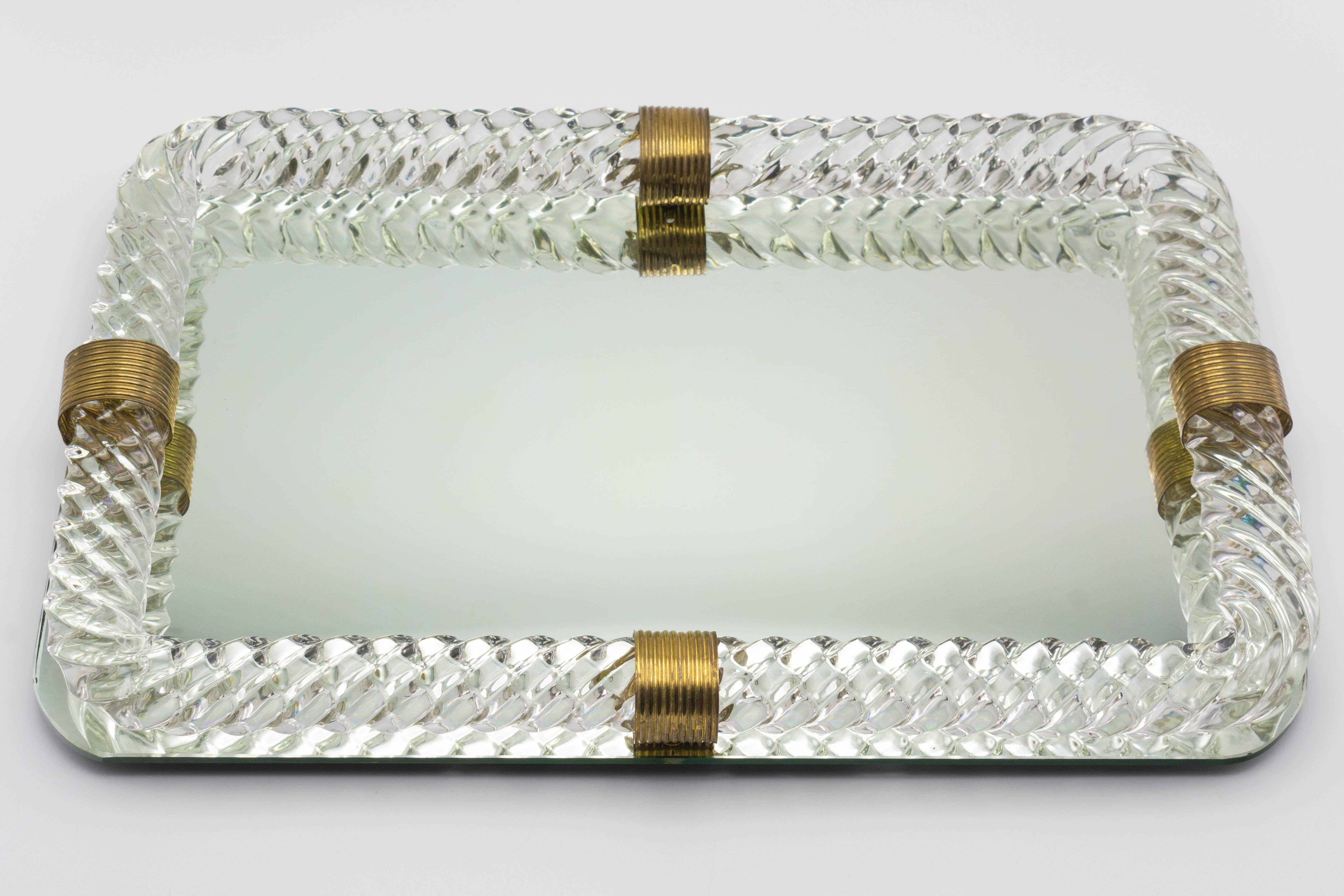 A mid century Italian Murano glass perfume or vanity tray by Paolo Venini. Clear glass twisted rope frame is attached to mirror tray with ribbed stamped brass bands.