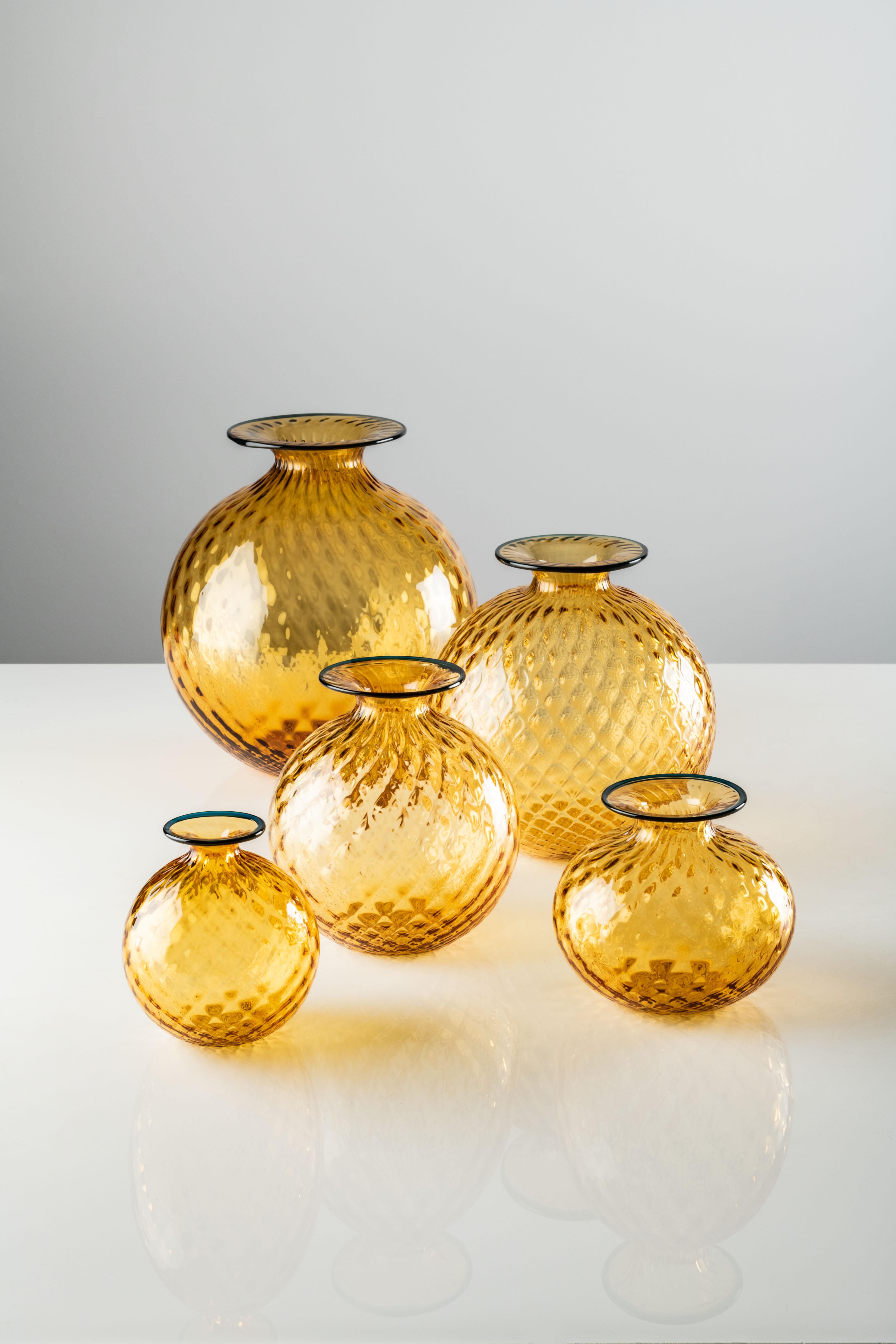 Jarrón pequeño Monofiore Balloton de cristal de Murano color ámbar de Venini. Monofiori rompe con la tradición en 1970 y vuelve a hacerlo en 2016. Pero su esencia sigue siendo la misma: parece blando, pero no lo es; es de cristal. La ilusión óptica