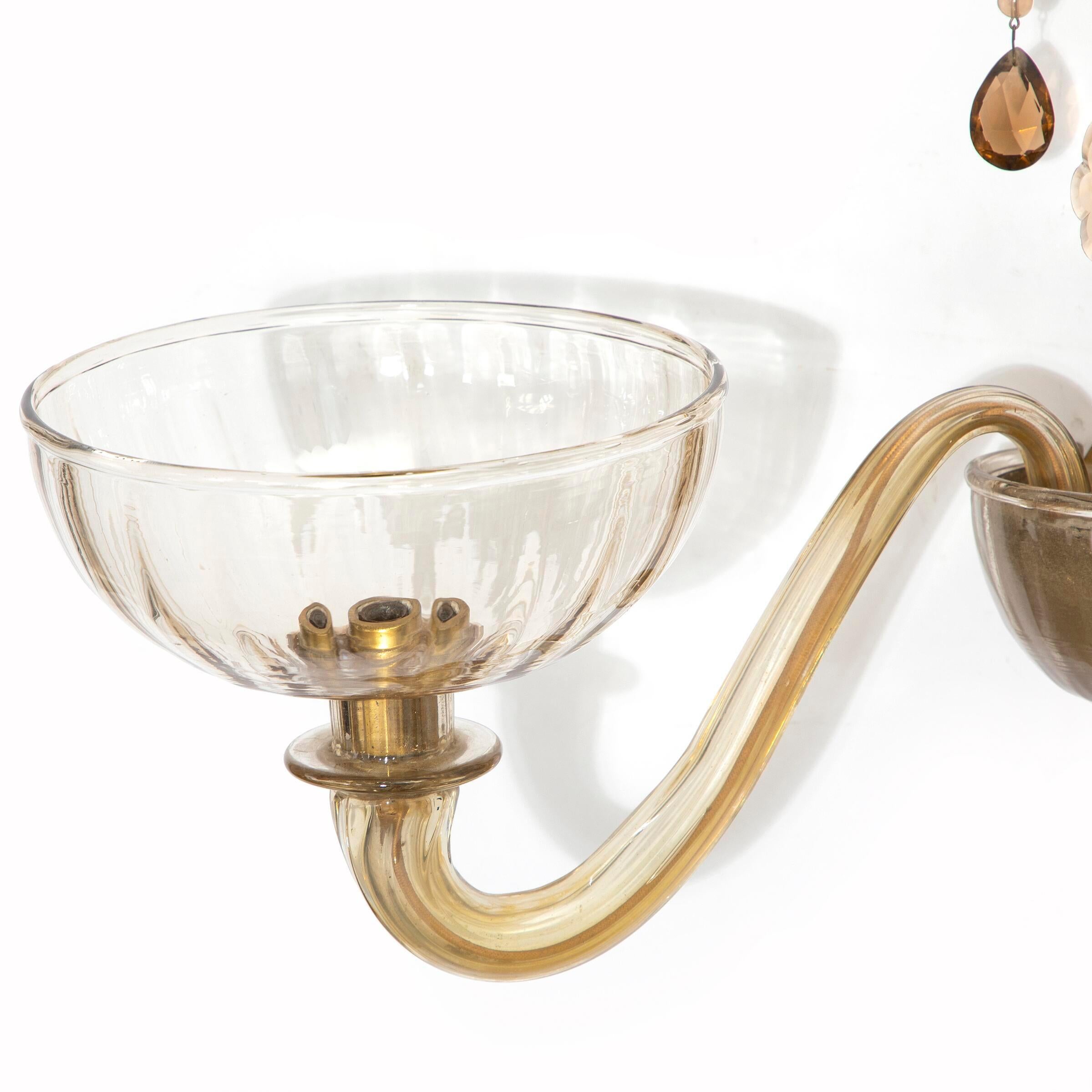 “Vetro Soffiato”. Smoke coloured glass two-branched wall lamp with prisms. Model 2191. This example made approx. 1930–1940s by Venini, Murano, stamped. H. 35 cm. W. 56 cm.