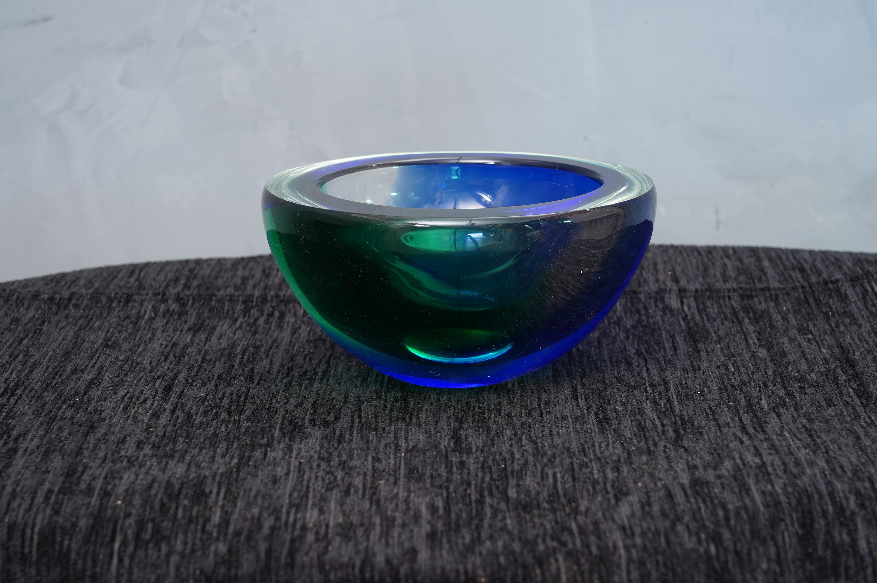 Ashtray formed by a particular submerged glass, signed Venini, with a wonderful double green and blue color.

The ashtray is in Murano glass, circular in shape, and with a particular transparent green and blue color. The signature is placed on the