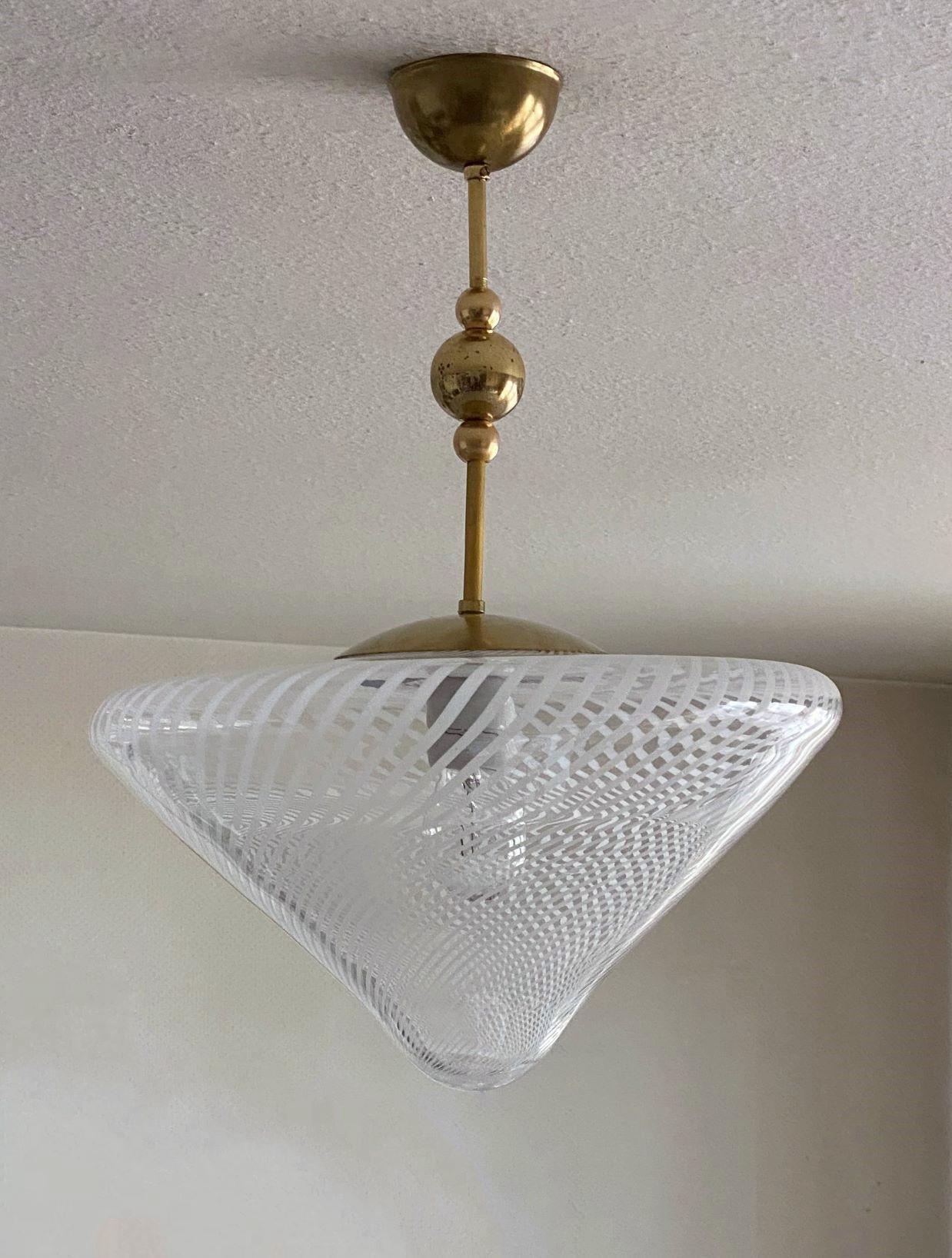 A large Venini flush mount or pendant attributed to Ludovico Diaz de Santillana, Series -Tessuto-, Italy, 1960s. Hand blown from white and clear Murano glass in conical shape, brass mounts.
It takes one E27 large sized bulb up to 100watt. LED bulbs