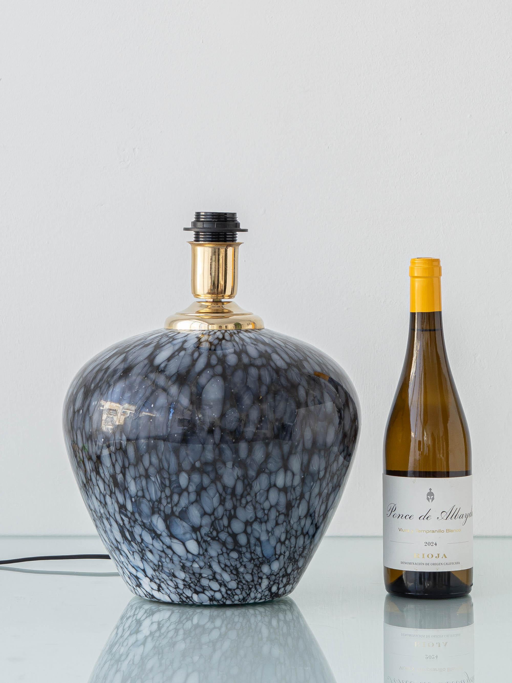 Une base de lampe de table raffinée en verre de Murano par Venini, le nom le plus célèbre du verre italien du 20e siècle. Le corps en forme de balustre est soufflé en verre noir avec des inclusions de lattimo blanc opaque, produisant un effet de