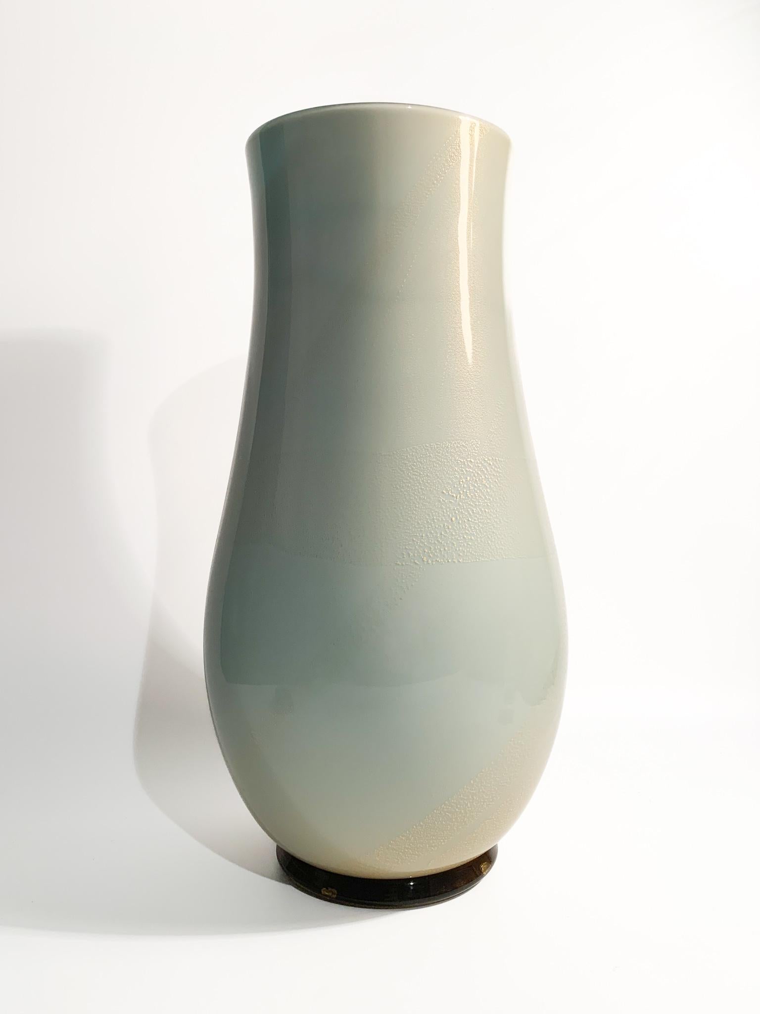 Vase in light blue Murano glass and gold leaf, made by Venini as a re-edition of the model designed by Tomaso Buzzi.

Ø 18 cm h 37 cm