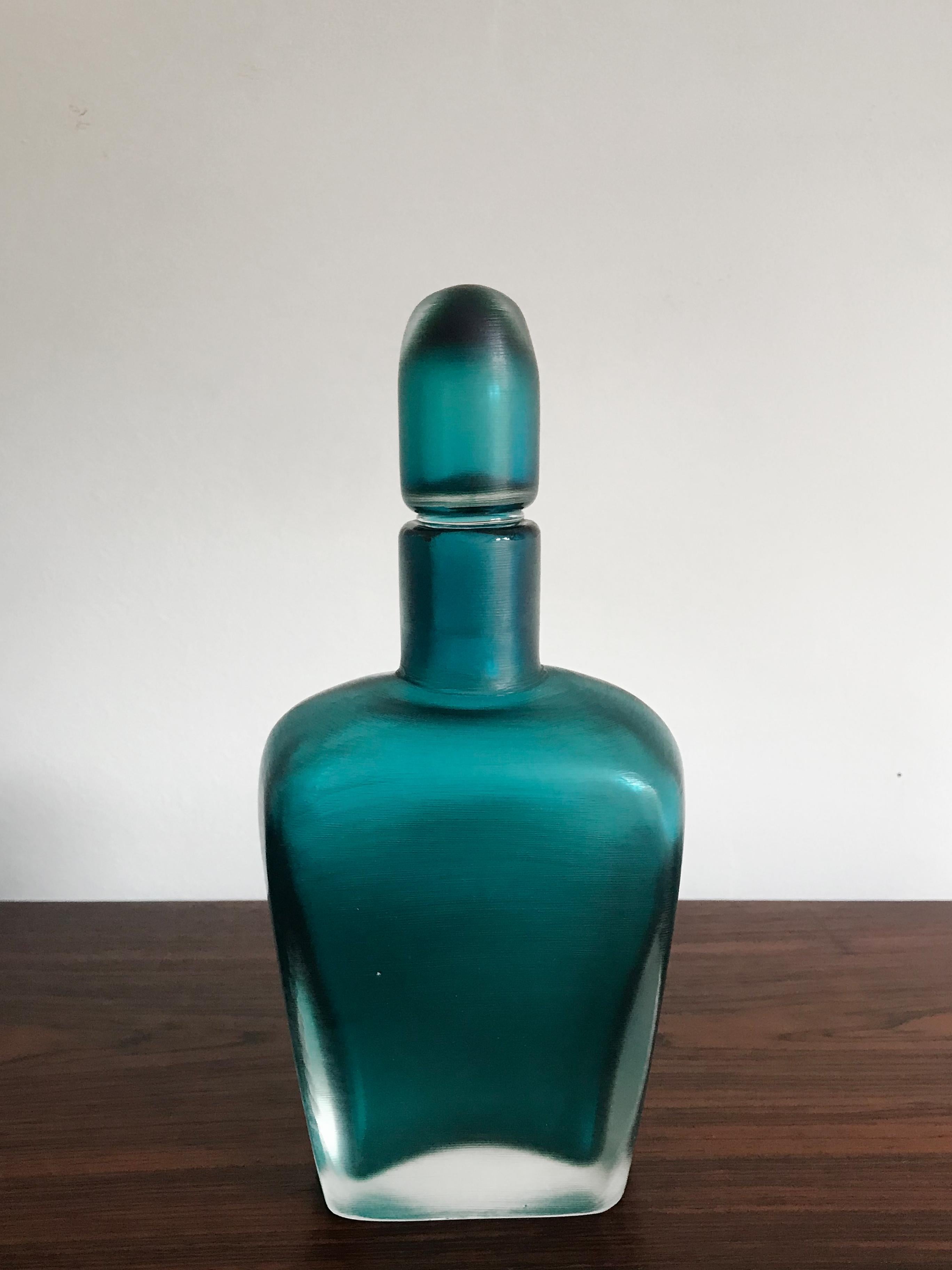 Italian light blue glass bottle with stopper, “Incisi” series, submerged glass with surface entirely worked by grinding produced by Venini Murano, Venini Italy 81 engraved signature under the base, Italy 1981

Please note that the item is original