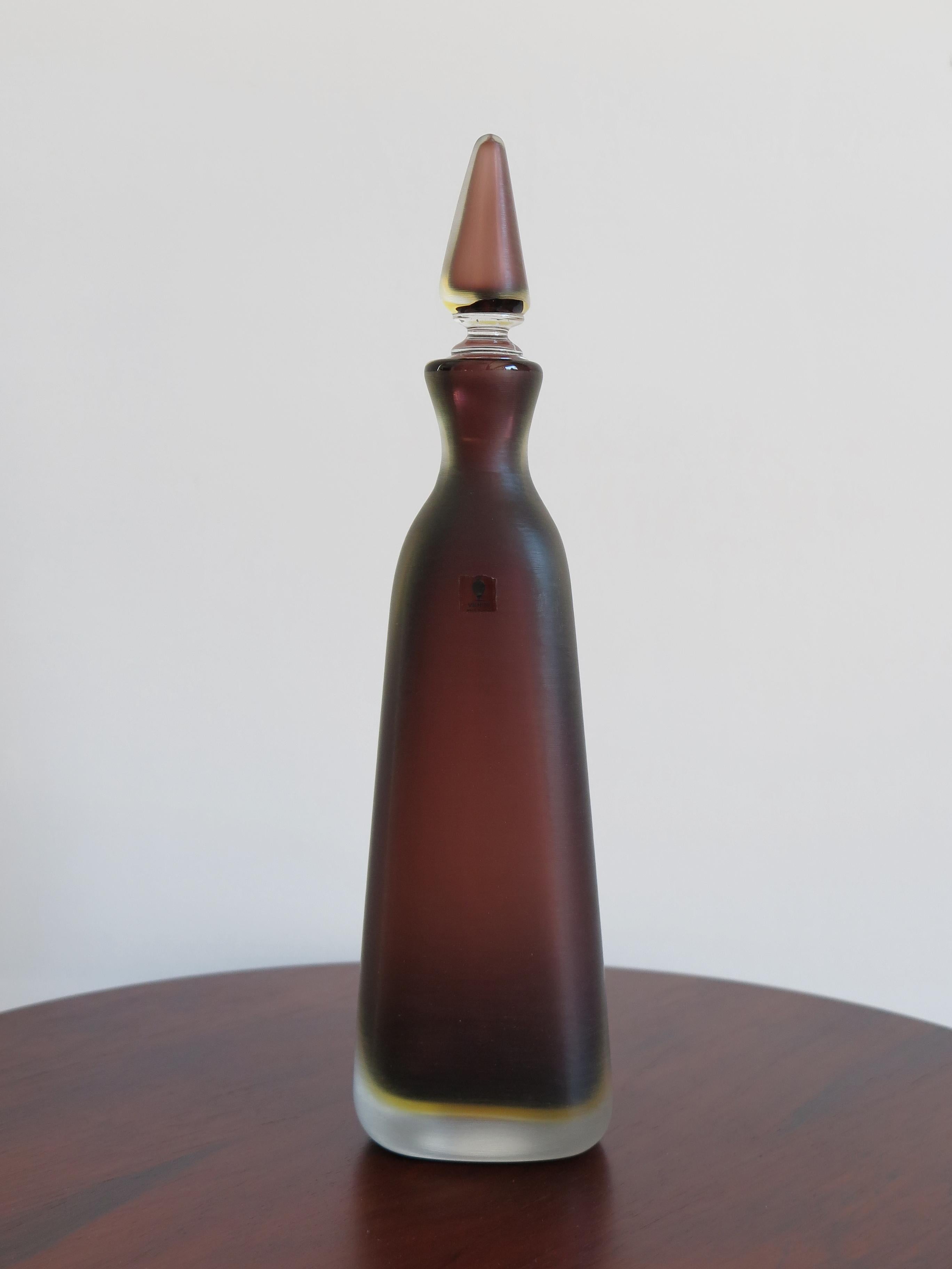 Italian glass bottle with stopper, “Incisi” series, in two-color submerged glass with surface entirely worked by grinding produced by Venini Murano.
Venini 80 engraved signature under the base and Venini Made in Italy adhesive label.
Limited