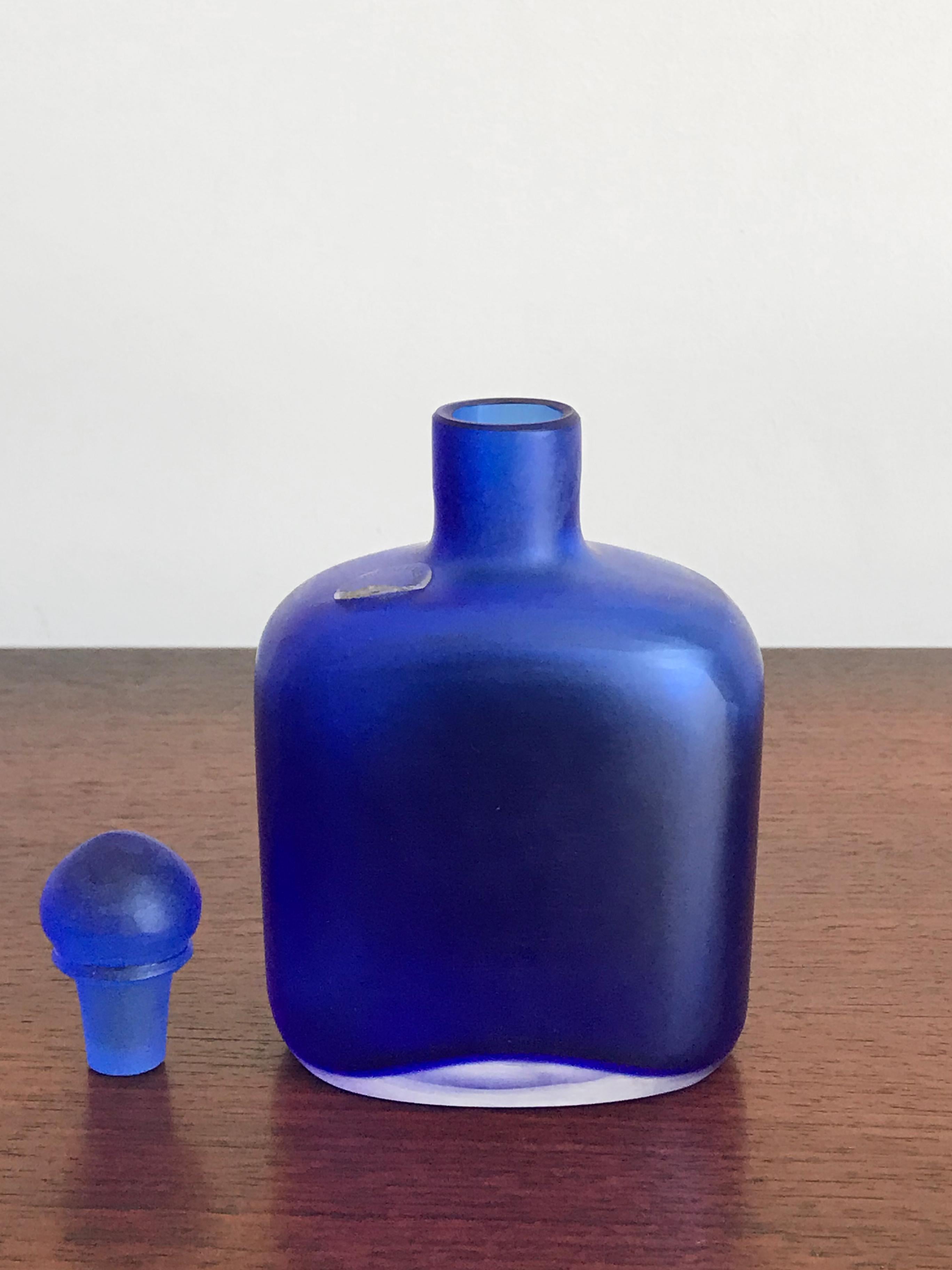 Amazing and fabulous very rare Italian handmade and blown bottle in bluette color glass with stopper, from the “Velati” series designed and produced by Venini Murano in 1995.

Logo Venini 1995 engraved by the producer on the bottom.
 