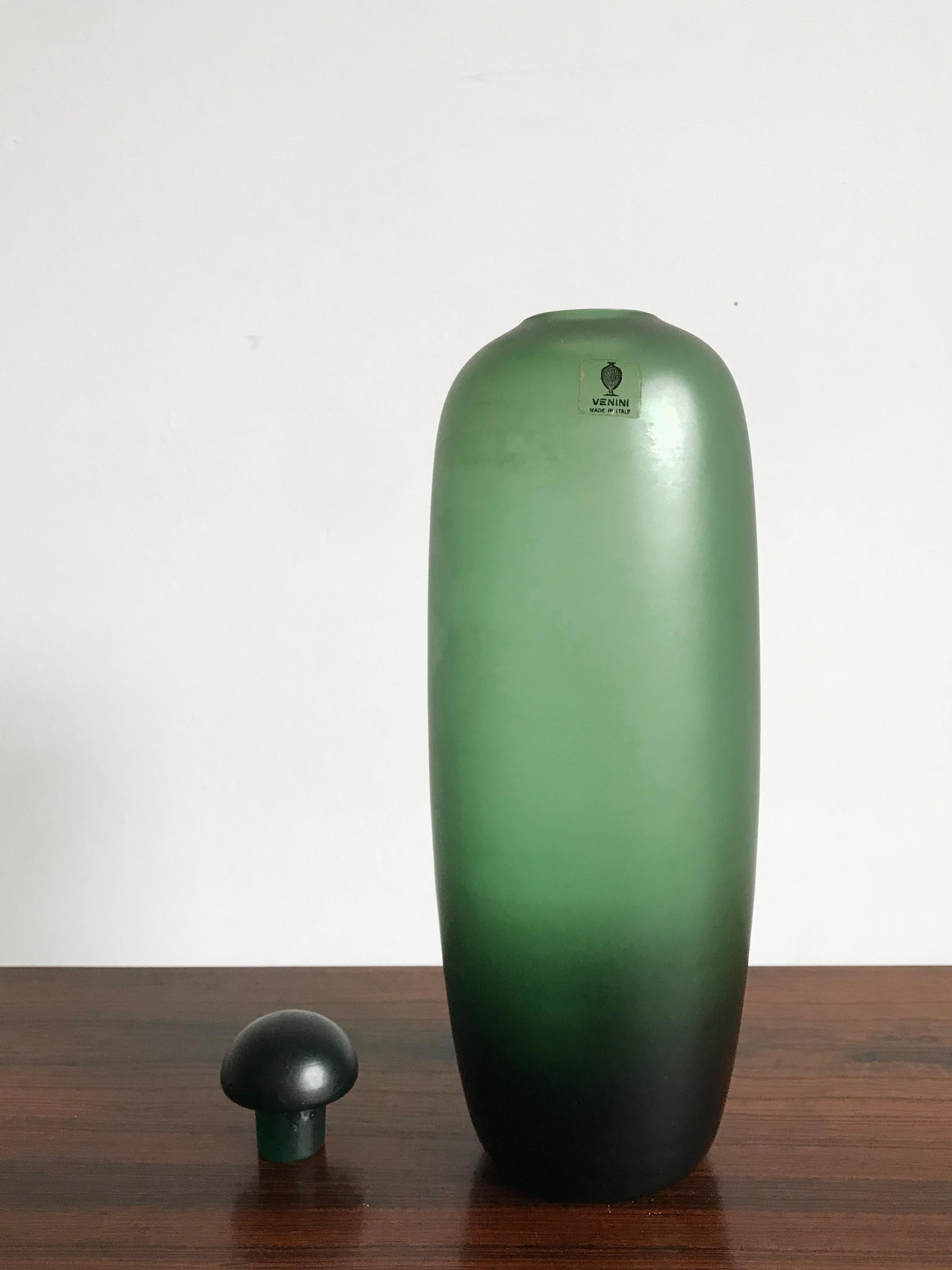 Amazing and fabulous Italian handmade and blown bottle in green color glass with stopper, from the “Velati” series designed and produced by Venini Murano in 1981.

Original Venini Murano label Made in Italy and engraved by the producer on the