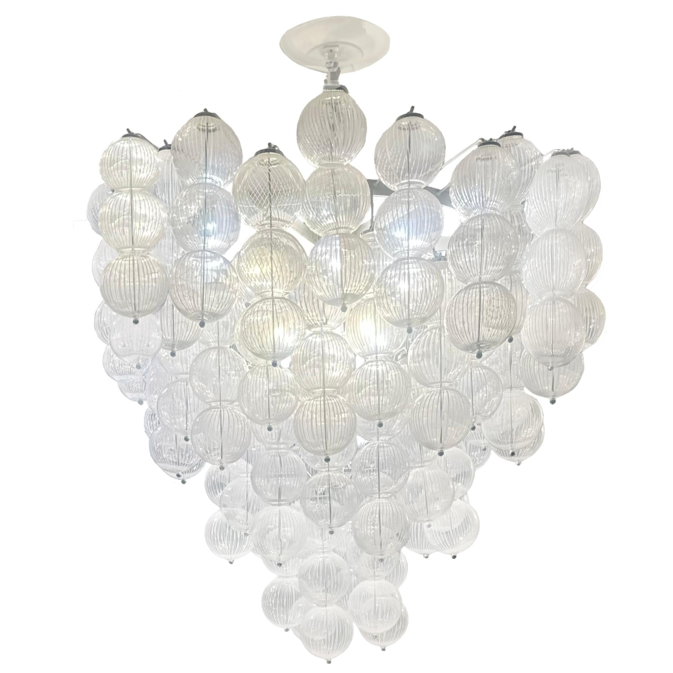 che presenta grappoli di sfere di vetro lattimo e trasparente di Murano in una disposizione a cascata a forma di cono. Una sottile striscia decorativa creata dal contrasto tra il vetro lattimo e quello trasparente dà l'impressione di una maggiore