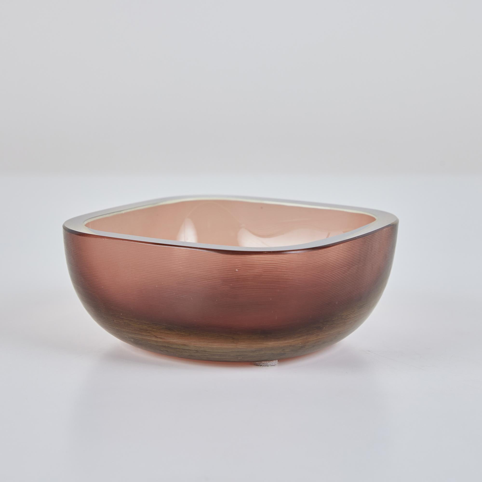 A small Murano glass dish by Venini, in a design commonly attributed to Carlo Scarpa, the company’s artistic director in the 1930s and early 40s. This modest square bowl has four sides and rounded corners. The textured glass is slightly darker at