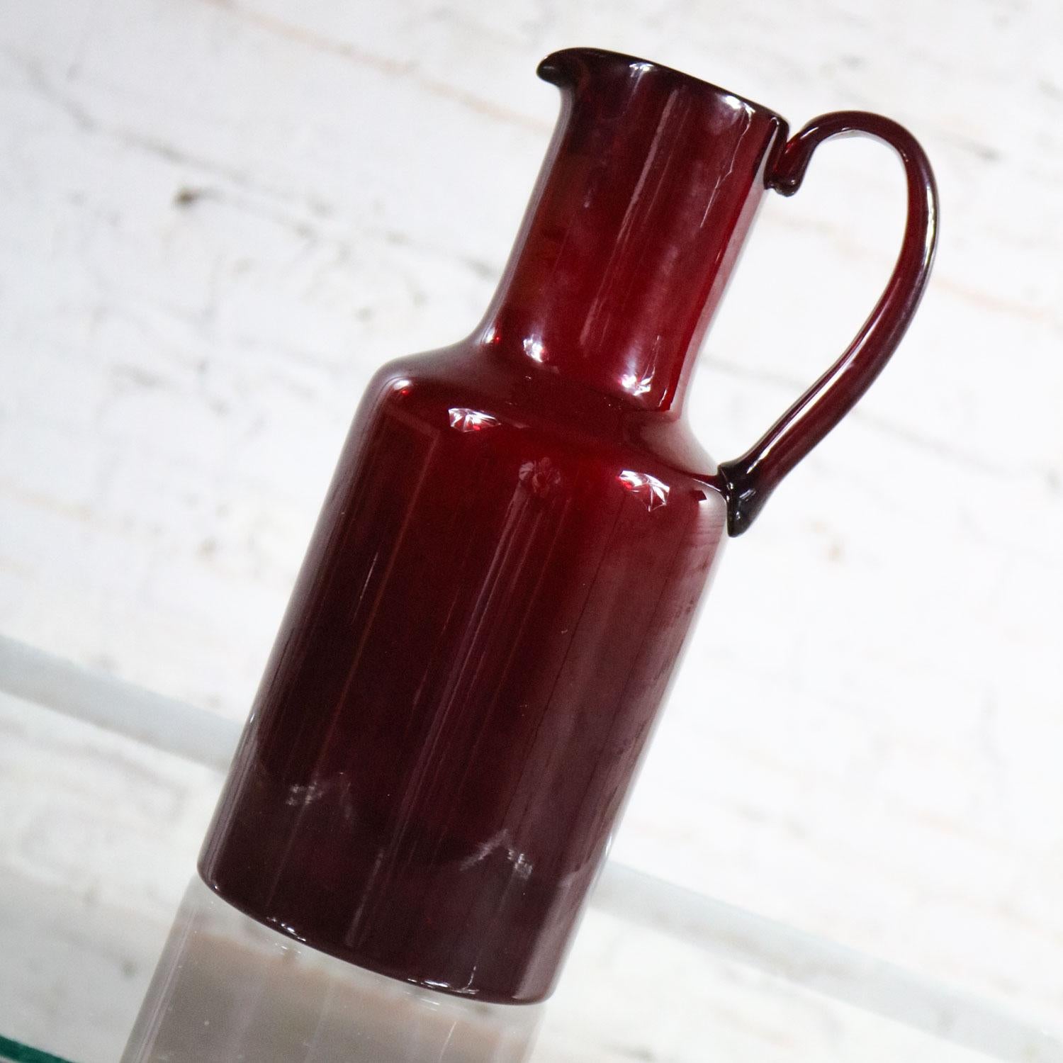 Wonderful Murano cocktail pitcher or carafe by Venini. It is cranberry red with an acid etched signature. Wonderful vintage condition with no chips, cracks, or chiggers. There is some shelf wear to the bottom. Please see photos. Circa