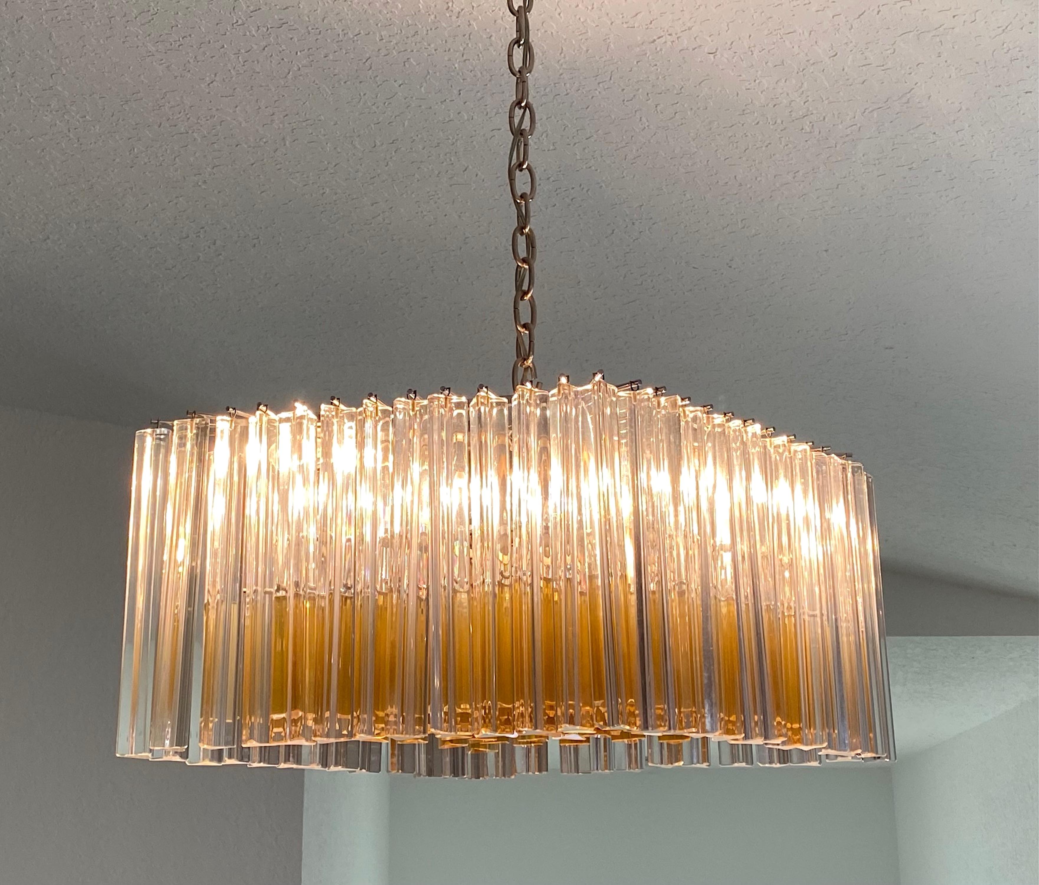 Magnifique lustre italien Venini circa 1970, avec des barres de verre Trilobi en couleur claire et longue dans la rangée extérieure, et ambre courte.  barres de couleur complétant toute la partie centrale inférieure, Italie.
Le lustre a une forme