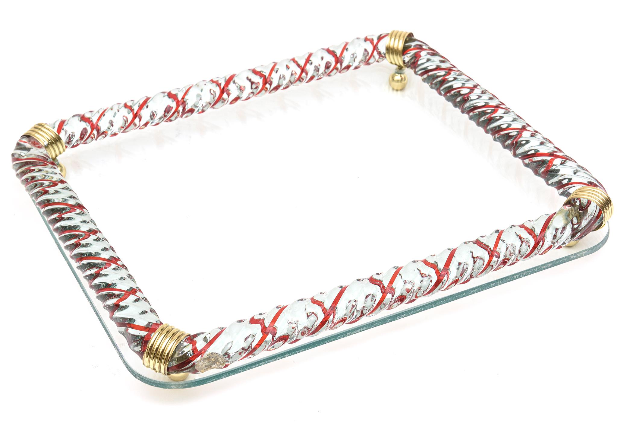 This gorgeous hand blown Italian Murano vintage glass tray by Venini is mid century modern. The red X style forms are randomly placed amidst the twisted clear rope glass. The tray is mirrored and the thickness of the roped twisted glass is 1.5
