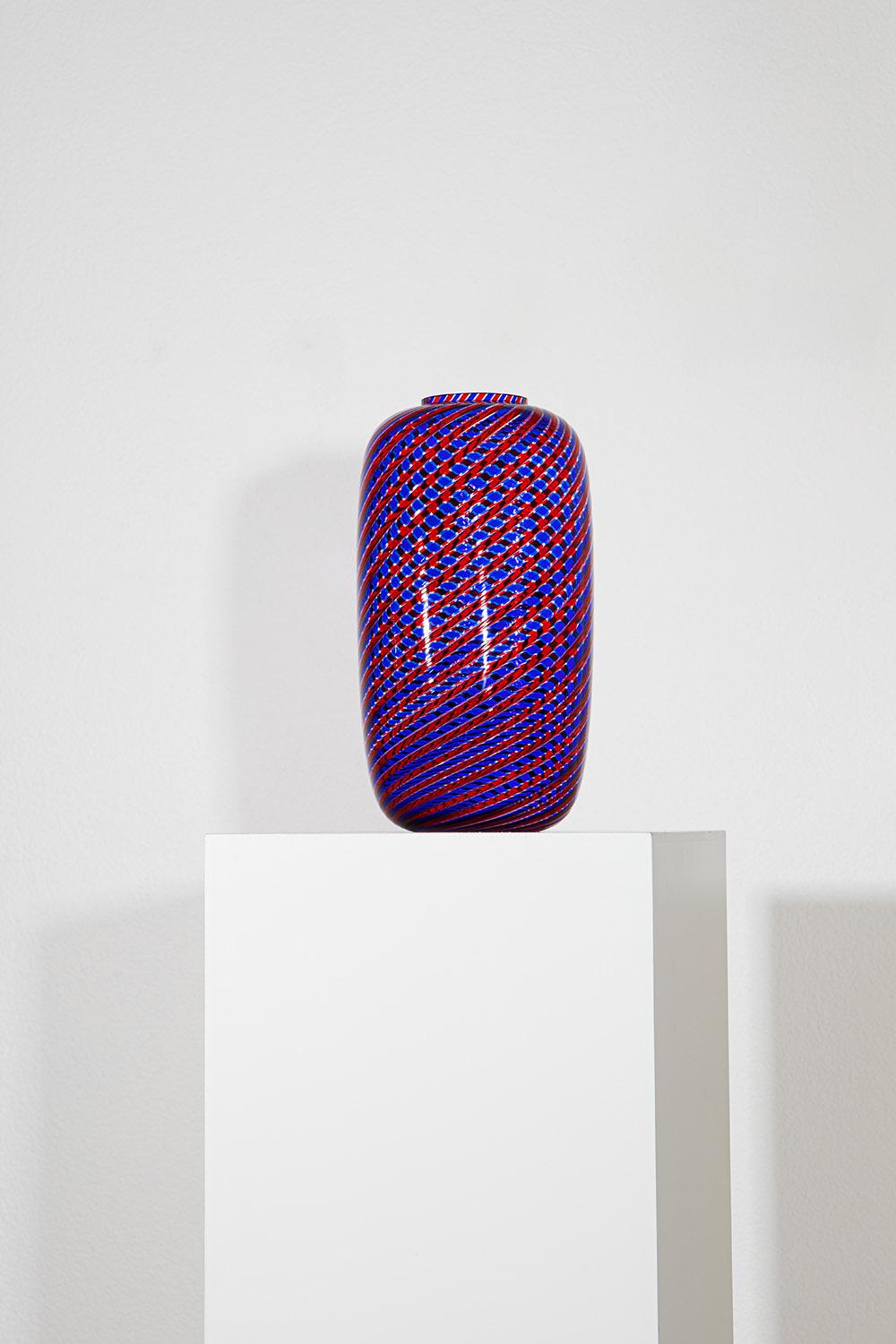 Questo splendido vaso viola del rinomato designer italiano Paolo Venini esemplifica la maestria della lavorazione del vetro di Murano, una tradizione che il marchio Venini porta avanti fin dalla sua fondazione. Realizzato a mano in Italia, questo