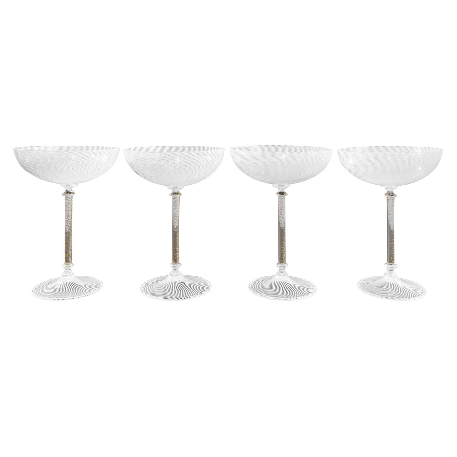Rare set of 4 hand blown champagne coupe glasses, mezza filigrana on top and bottom with gold foil in the stems, attributed to Tapio Wirkkala for Venini, Murano Italy, 1960s. These are extraordinary.

Reference:
Venini Catalogue Raisonne