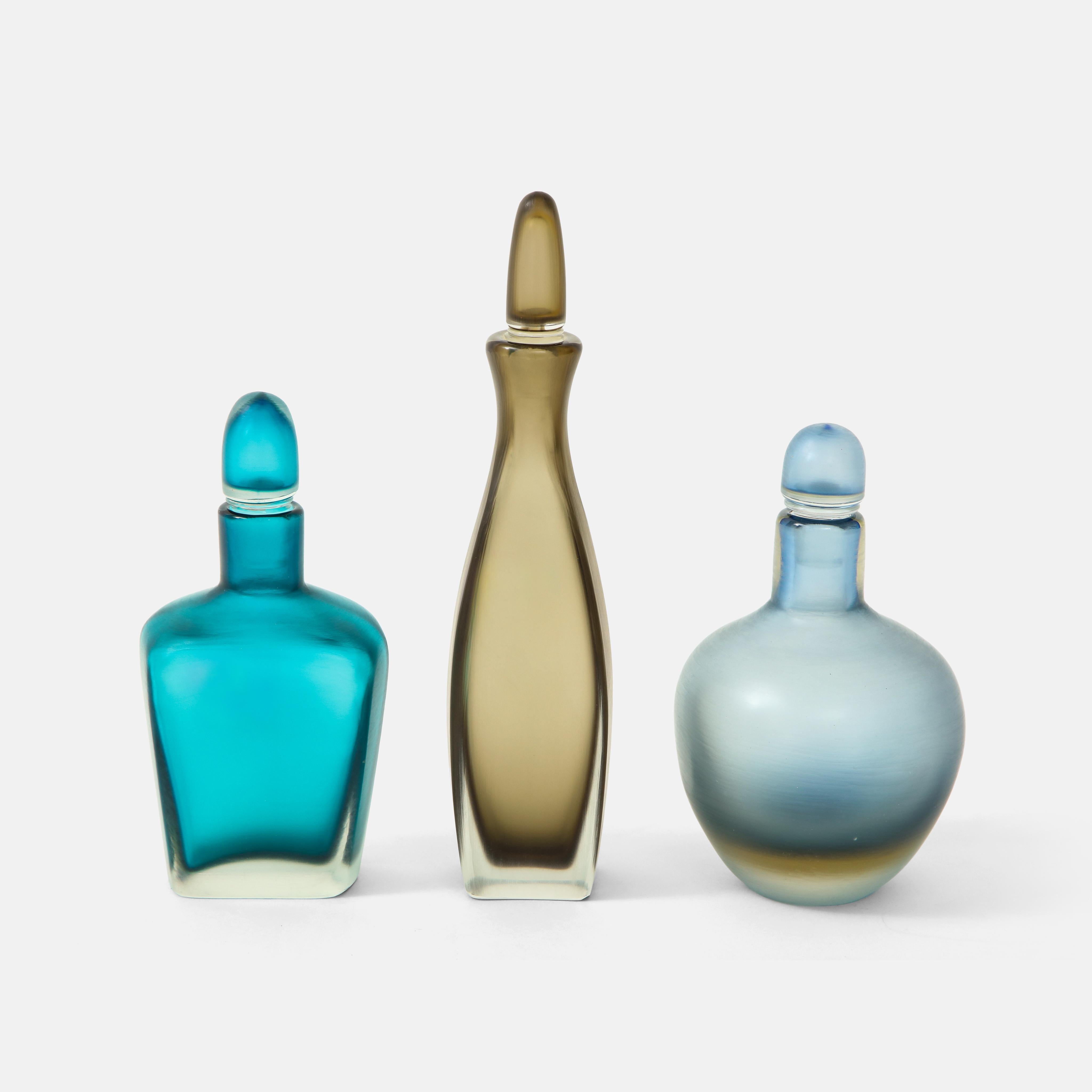 Venini set of three glass bottles with stoppers in composite glass with finely wheel-engraved finishes of delicate creases, incised on bottom of each bottle 