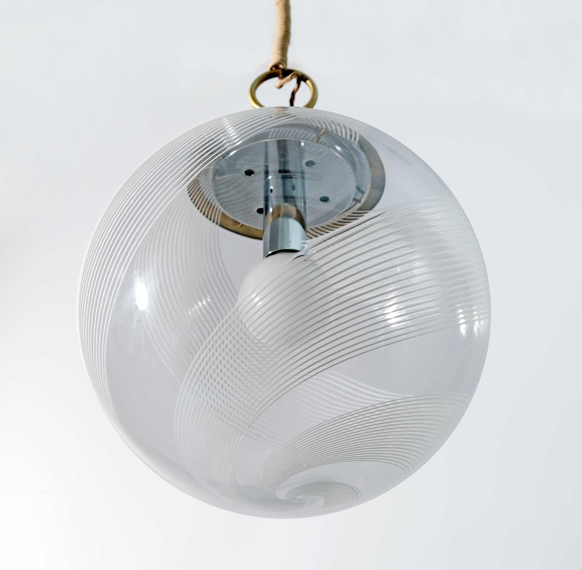 Large 1970s Space Age suspension lamp with one light in Murano artistic glass and brass structure. The transparent glass shade features the classic movement of the double spiral band that wraps it from the bottom up, offering a fascinating visual