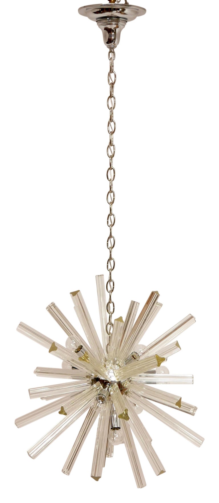 An unusual nine light starburst Sputnik style crystal chandelier, having two differing lengths of crystals in a trideri shape with the sockets interspersed among the crystal rods. Heavy chrome plating on the steel covered sockets and frame