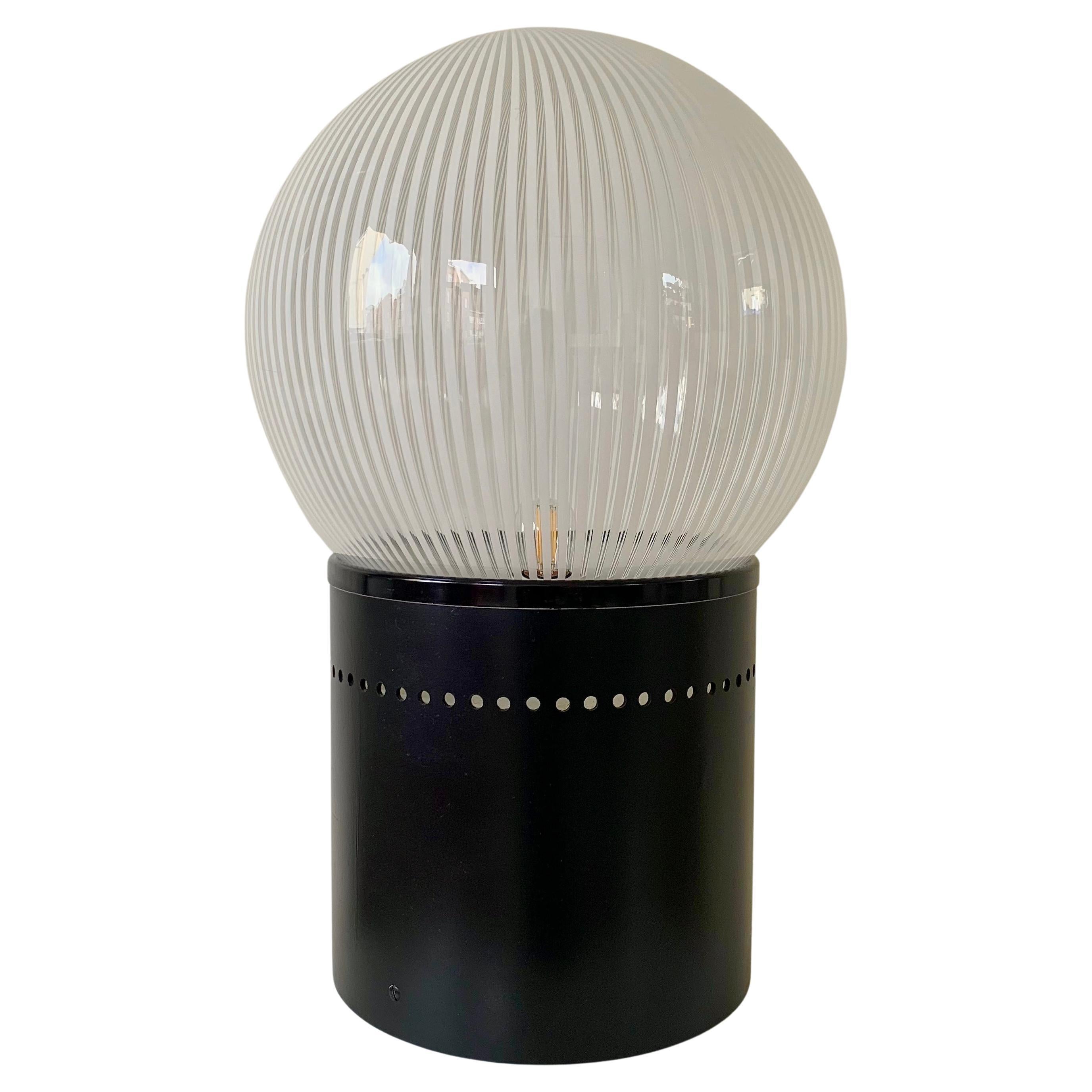 Lampe de table en verre Venini, vers 1960, Italie.
Sphère en verre Venini blanc et transparent strié sur une base laquée noire.
Recâblé, prêt à l'emploi.
Dimensions :  56 cm de hauteur, 34 cm de diamètre.
Bon état d'origine.
Tous les achats sont