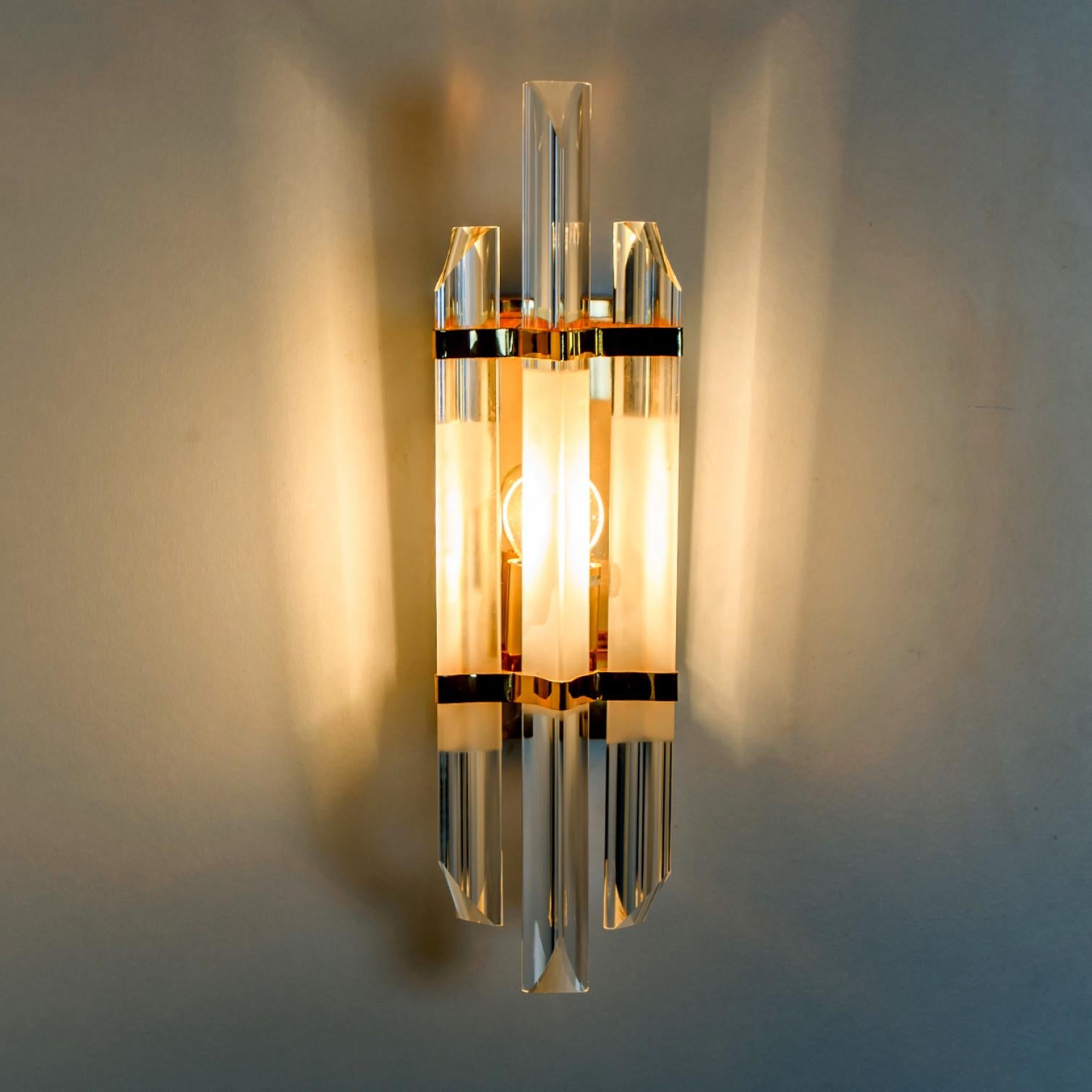 Beautiful triangle shaped glass wall sconces featuring three long crystal clear glass tube-like rods, with brass details and back plate. Illuminates beautifully. High-end pieces.

Cleaned and well-wired, in full working order and ready to use. The