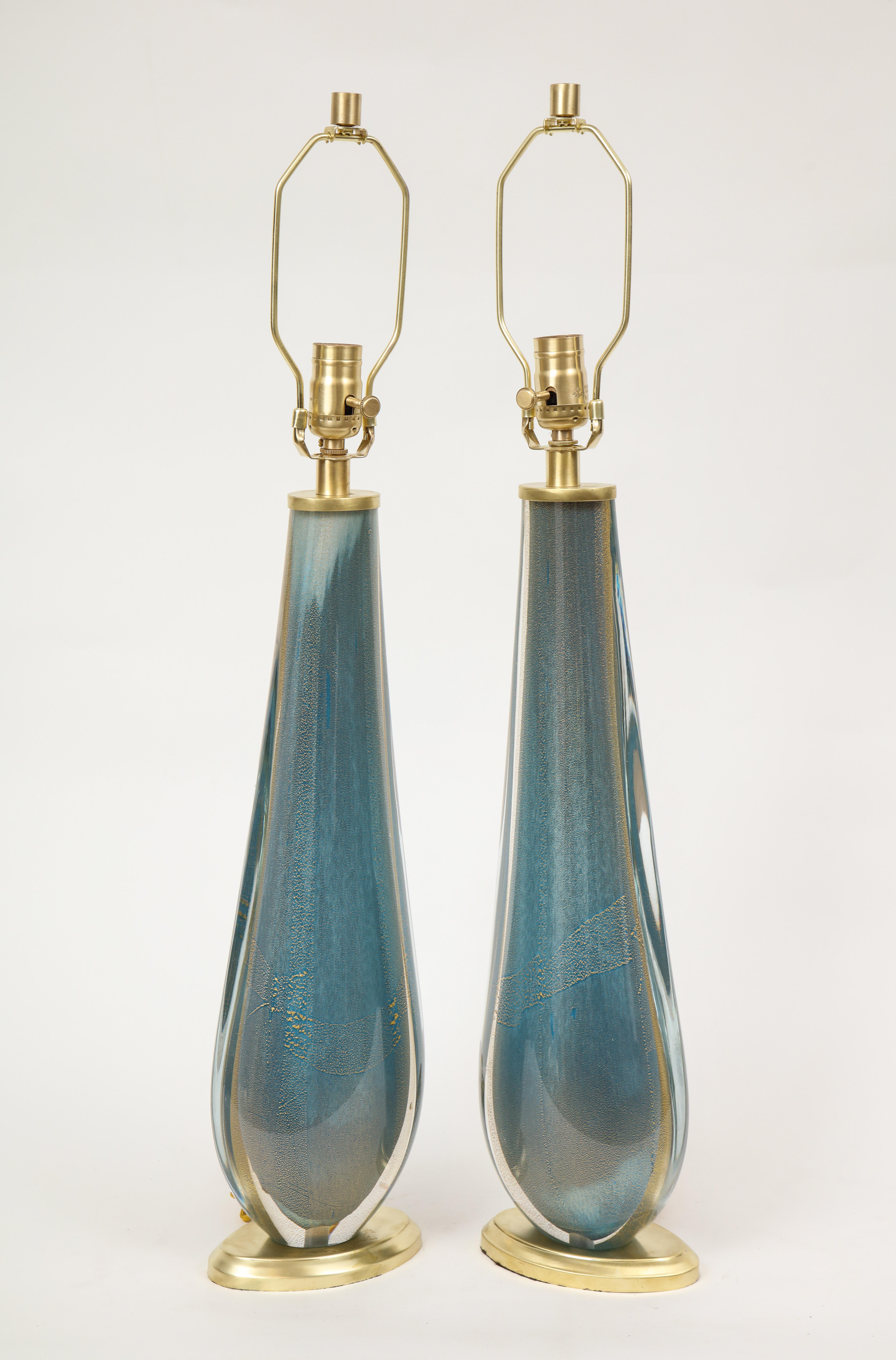 Pair of modernist French blue teardrop shaped Murano glass lamps with 22 karat gold overlay resting on oval satin brass platform bases. Rewired for use in the USA.