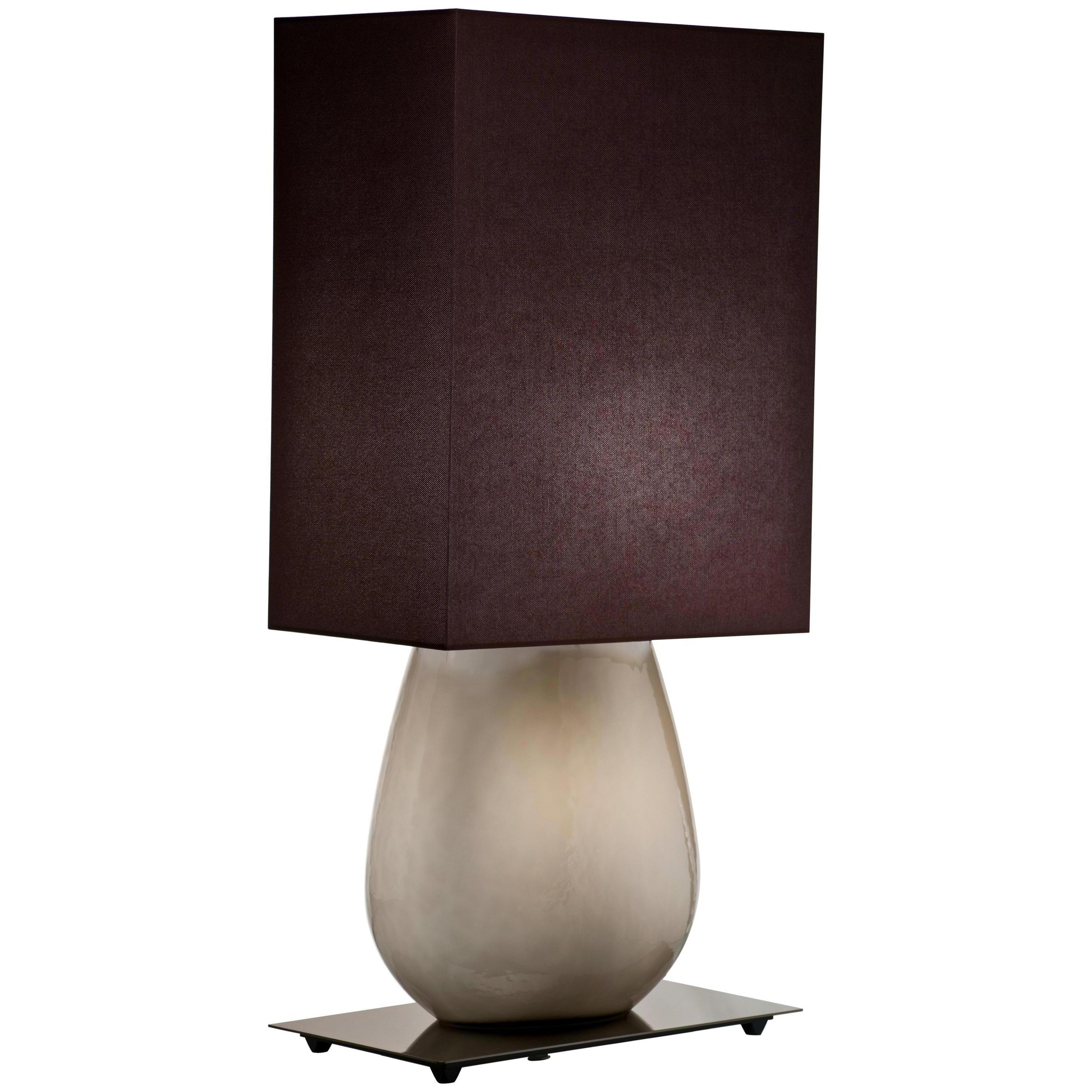 Sultani table lamp, designed by Leonardo Ranucci and manufactured by Venini, features an hand-made blown glass body with fabric shade. Indoor use only.

Dimensions: W 24.5 cm x D 40 cm x H 98 cm. Also available in a smaller version: W 20 cm x D