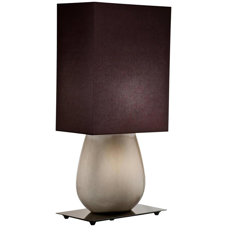 Sultani table lamp, designed by Leonardo Ranucci and manufactured by Venini, features an hand-made blown glass body with fabric shade. Indoor use only.

Dimensions: W 24.5 cm x D 40 cm x H 98 cm. Also available in a smaller version: W 20 cm x D