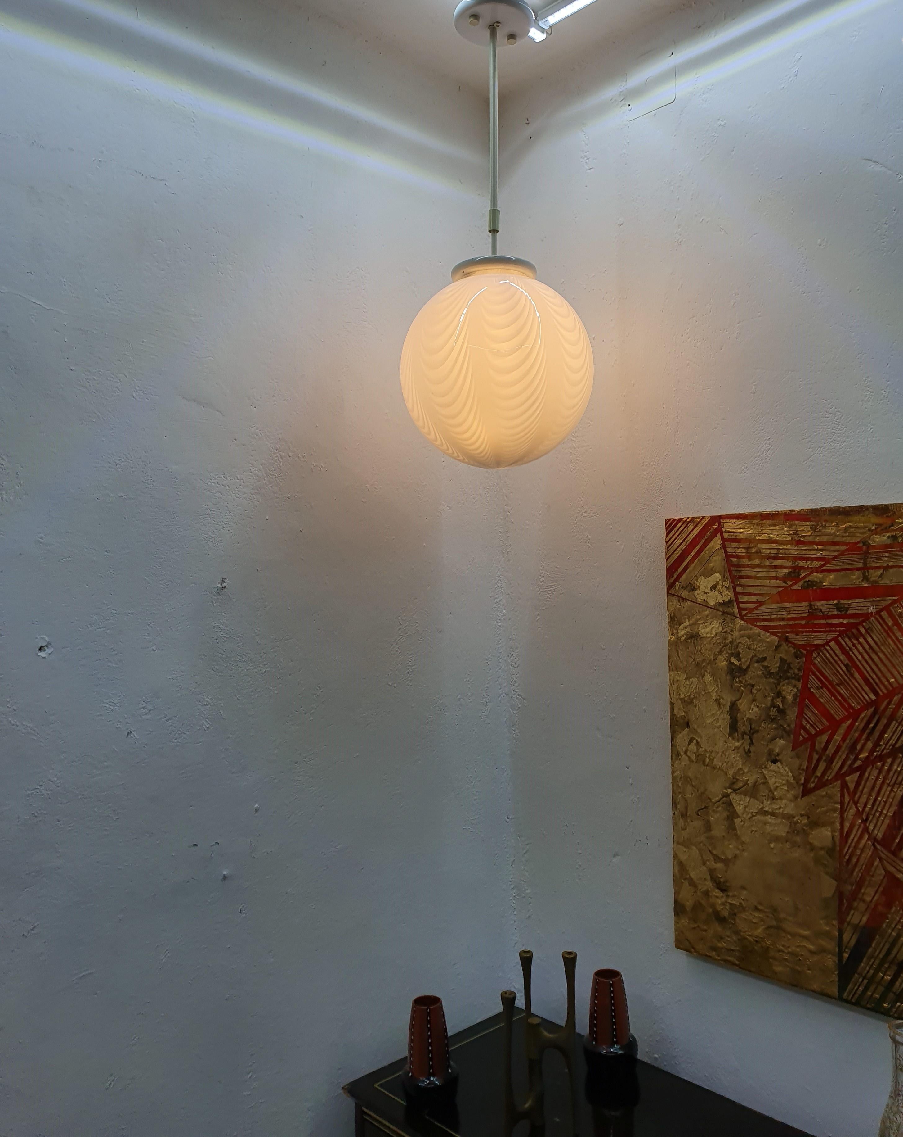 Bellissima lampada a sospensione a forma di sfera, in vetro di Murano bianco soffiato a bocca, attribuita a Venini, circa 1970.
La lunghezza di questa lampada è di 90 cm, ma può essere allungata se lo si desidera. 
Misure: Diametro 35 cm.

