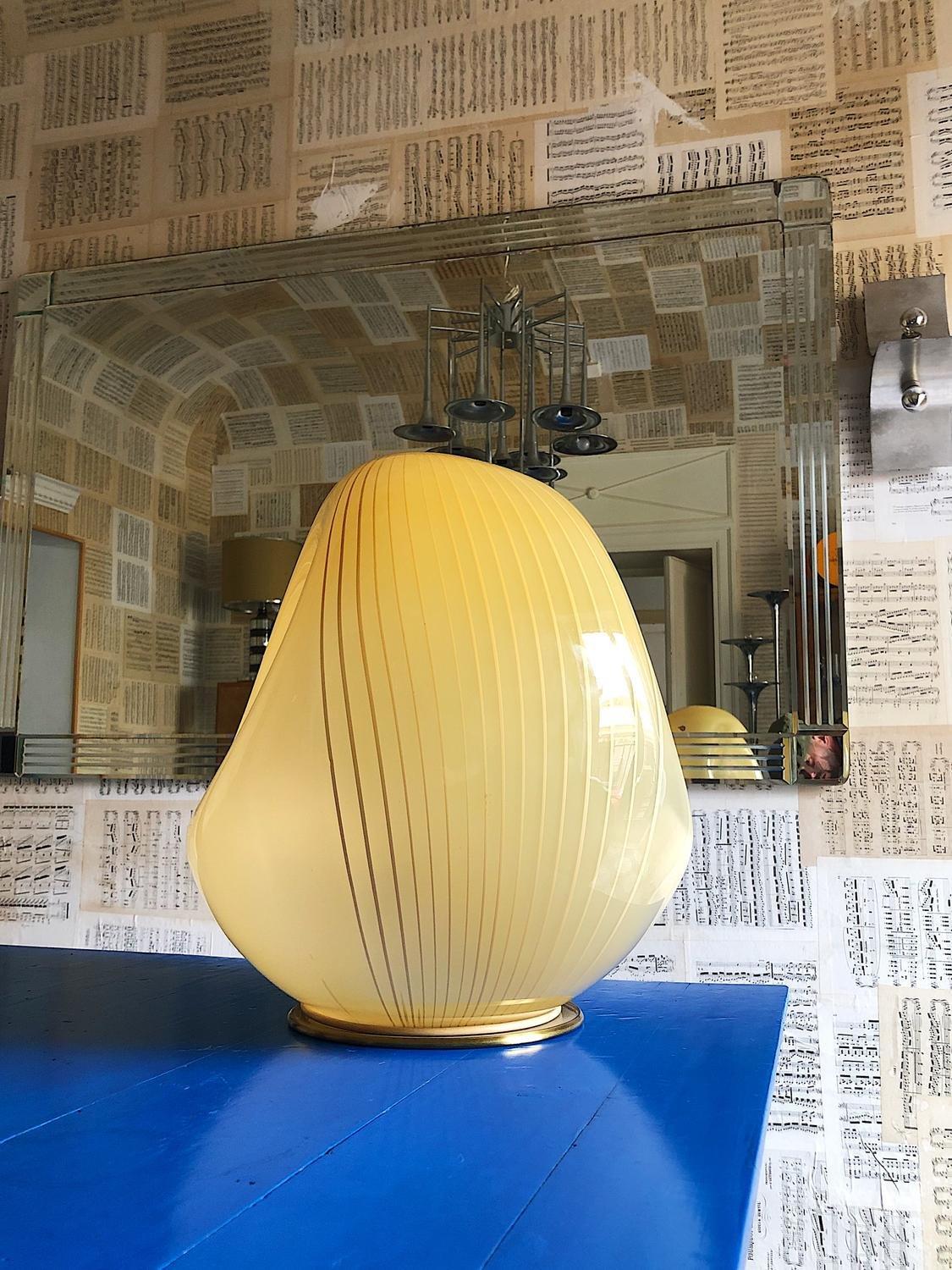 Super rare lampe de table en verre de Murano conçue par Carlo Scarpa pour Venini, années 1940.
Le globe a une forme irrégulière. La couleur passe du blanc, du beige au jaune lgt avec un décor à rayures.
Diamètre 40cm. Vintage, en excellent