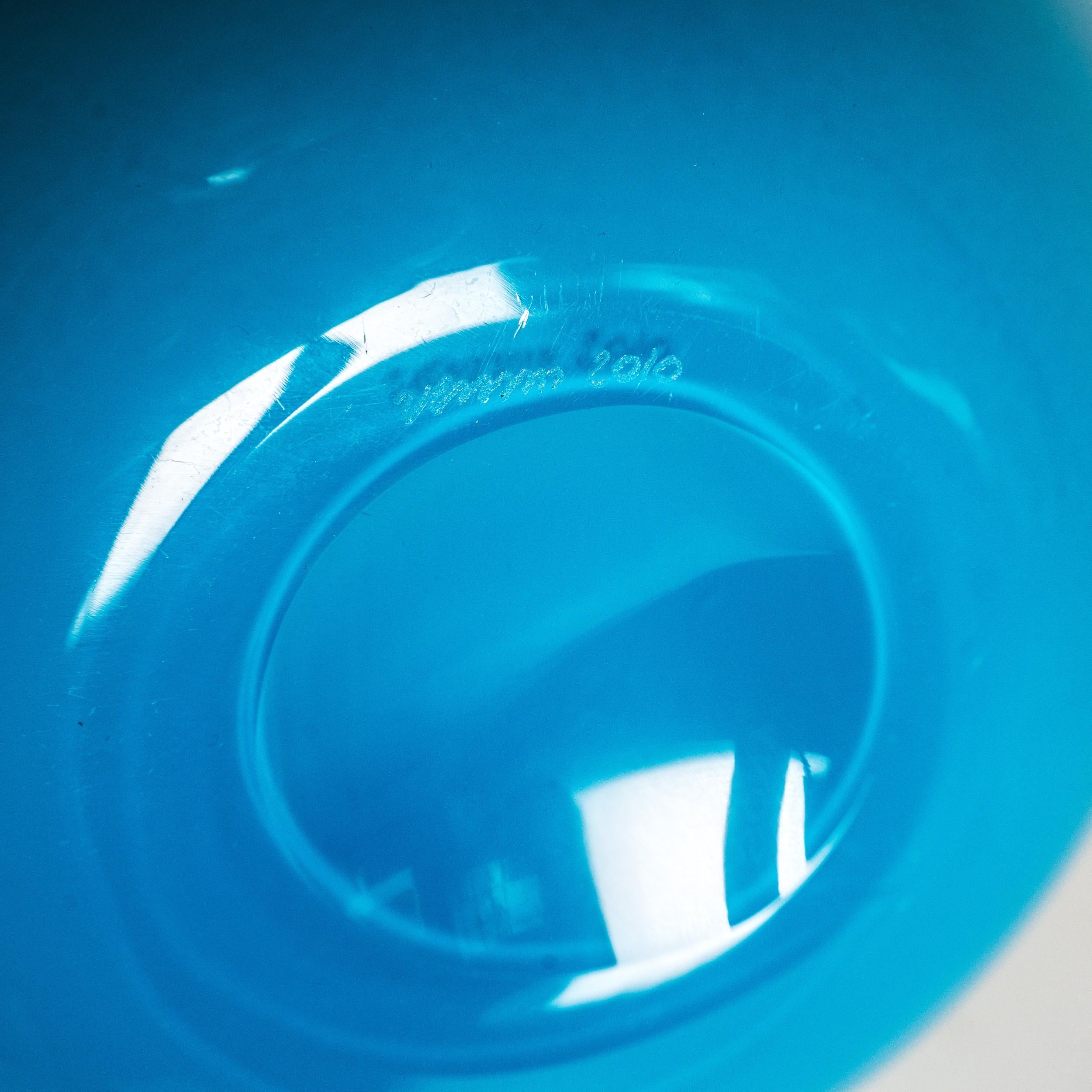 Vase intemporel Venini Fazzoletto, modèle 700.02, en verre opalin aigue-marine et vert, gravé Venini 2004 avec boîte et documents.
Soufflé et façonné à la main selon la technique traditionnelle de la mano volante, il crée le bord ondulé