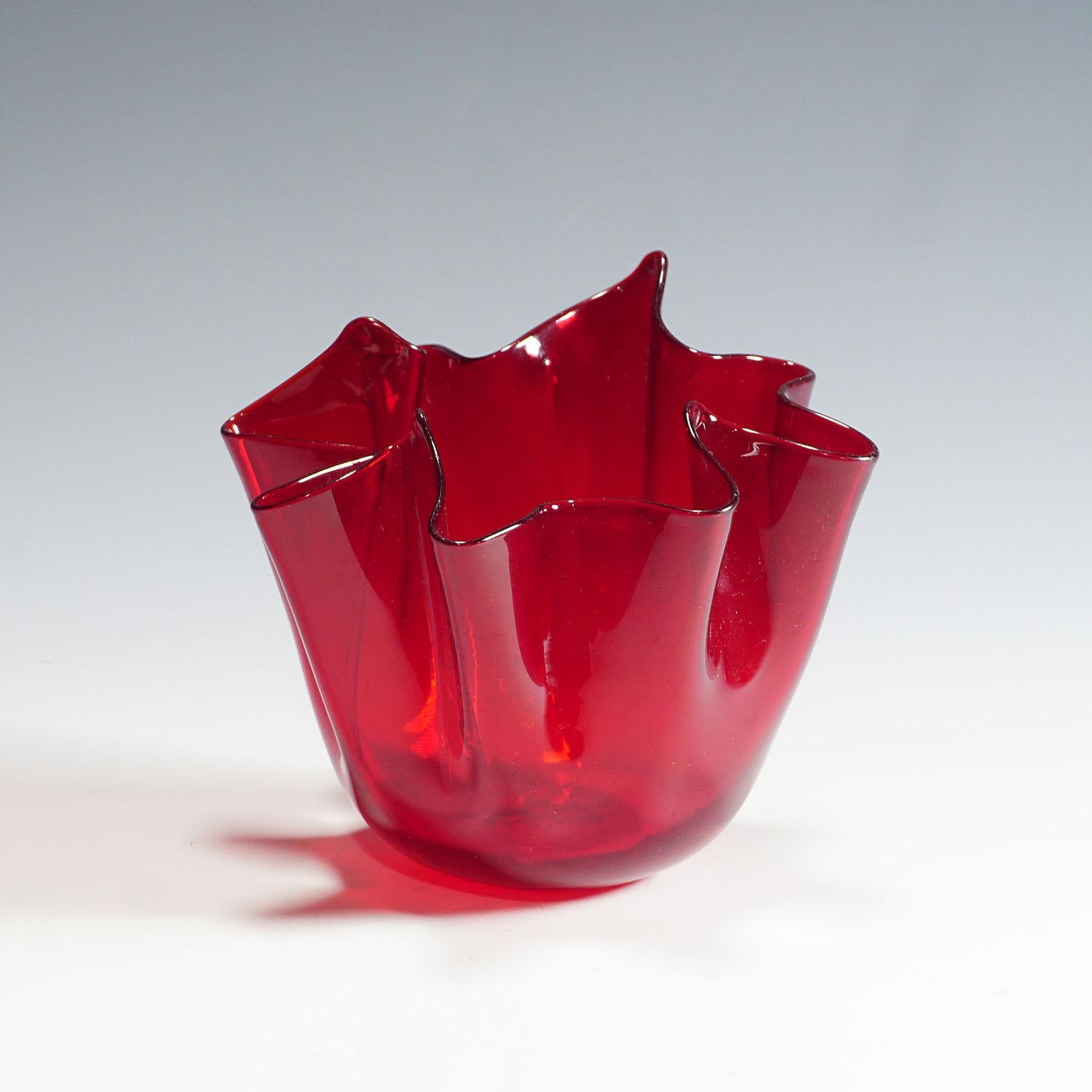 A vintage Fazzoletto (handkerchief) vase in transparent red glass. Manufactured ca. 1950s by Venini, Venice after a design of Fulvio Bianconi. On the base with round acid etched signature 'venini ITALY murano'. Venini model number 3927. An iconic