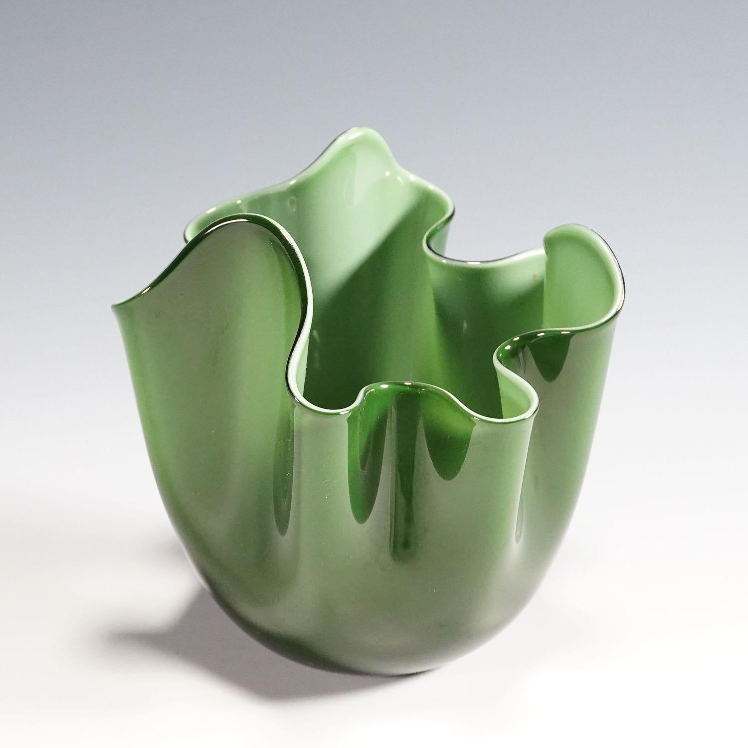 Un vase Fazzoletto en verre opalin vert et vert clair avec un verre transparent. Il a été fabriqué en 2015 par Venini, à Venise, d'après un dessin de Fulvio Bianconi. Sur la base se trouve la signature incisée 