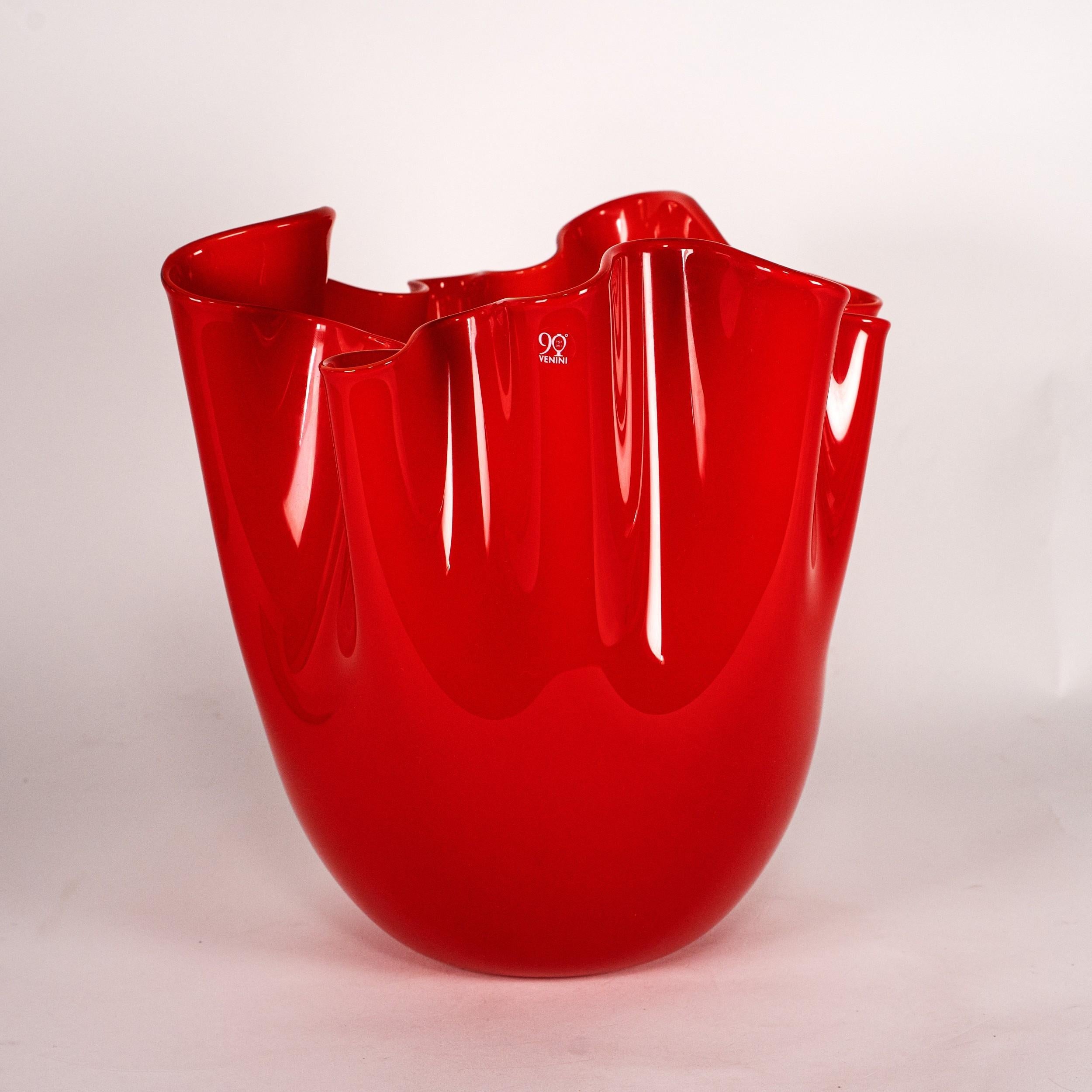 Jarrón icónico Venini Fazzoletto, modelo 700.00 90º Aniversario, de cristal rojo, grabado con diamante Venini 2004, con caja y documentación. 
Edición especial producida en 2012 para conmemorar el 90º Aniversario de Venini (1921-2011). Creada como