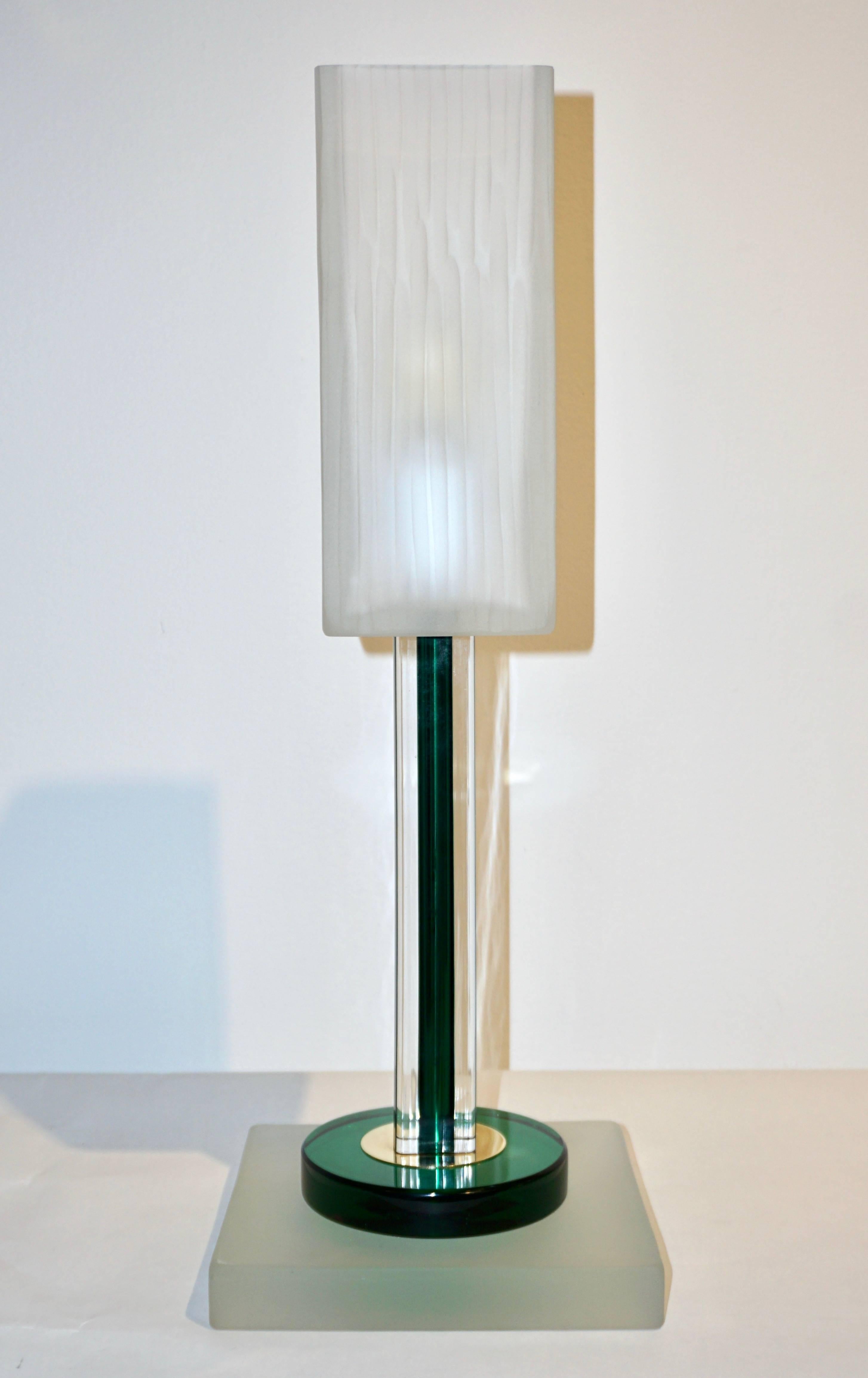 A rare Italian Minimalist pair of lamps signed Venini 1992 of modern geometric design, the square shaped central support presents a green Murano glass core worked ad incalmo overlaid in crystal clear glass, raised on a stepped base with a green