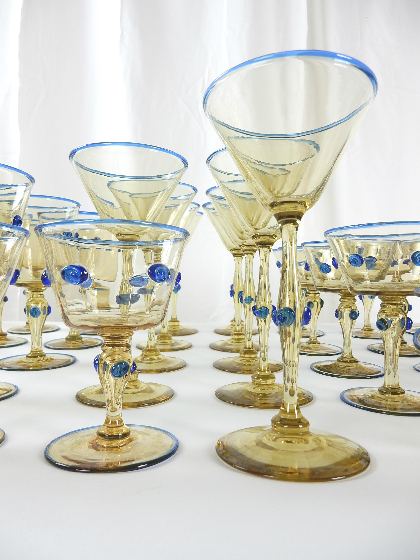 Venice Italy glass service set of gorgeous honey colored glass dotted and trimmed in cobalt blue, circa 1950s.
attributed to Vittorio Zecchin design, consisting of 86 pieces total.
12 ea. tall wine goblets
8 ea. short wine goblets
9 ea.