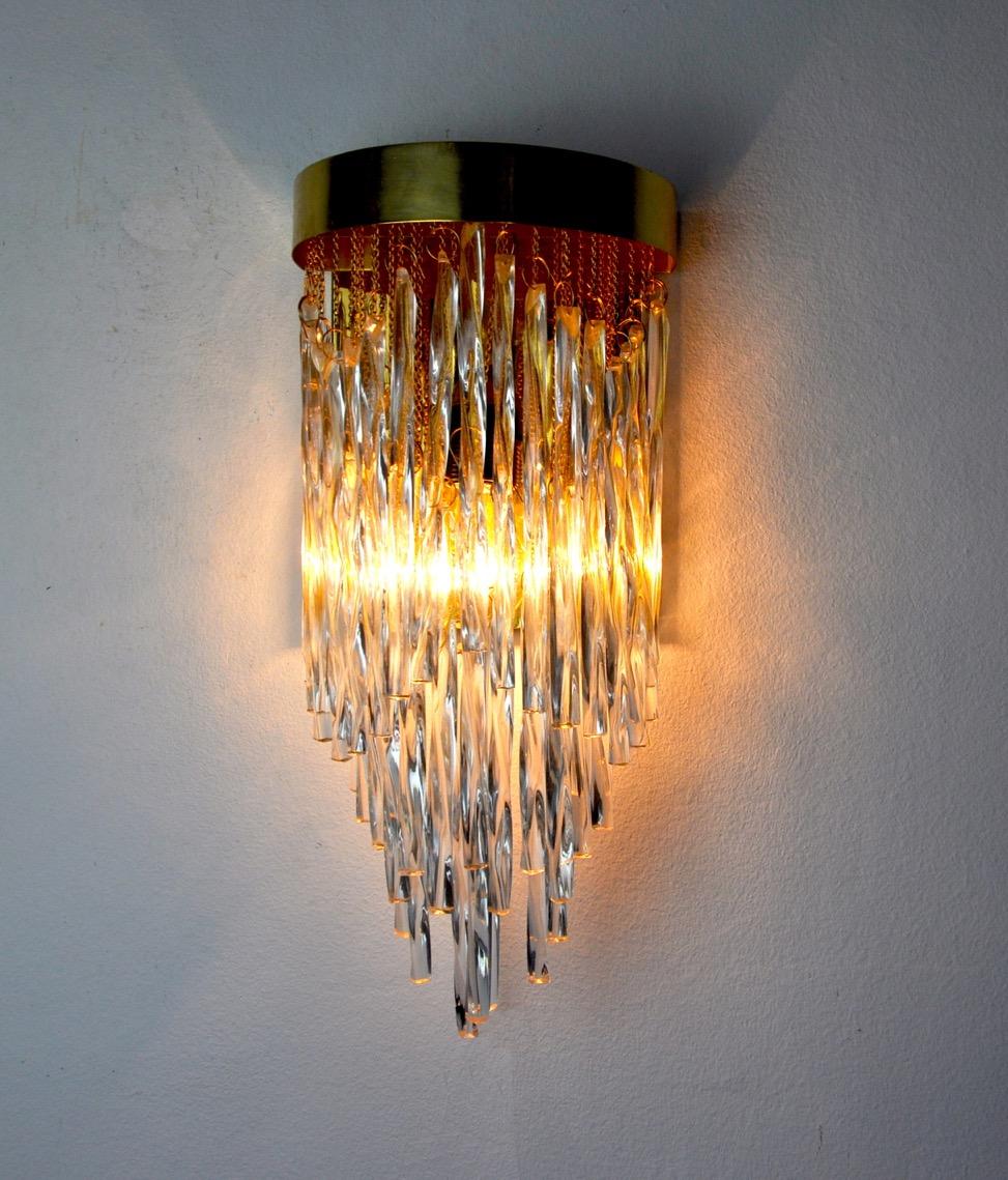 Superb and rare venini waterfall wall lamp designated and produced in italy in the 1960s.

Cut and suspended crystals creating a gradient and cascade effect, all supported by a golden metal structure.

Unique object that will illuminate and